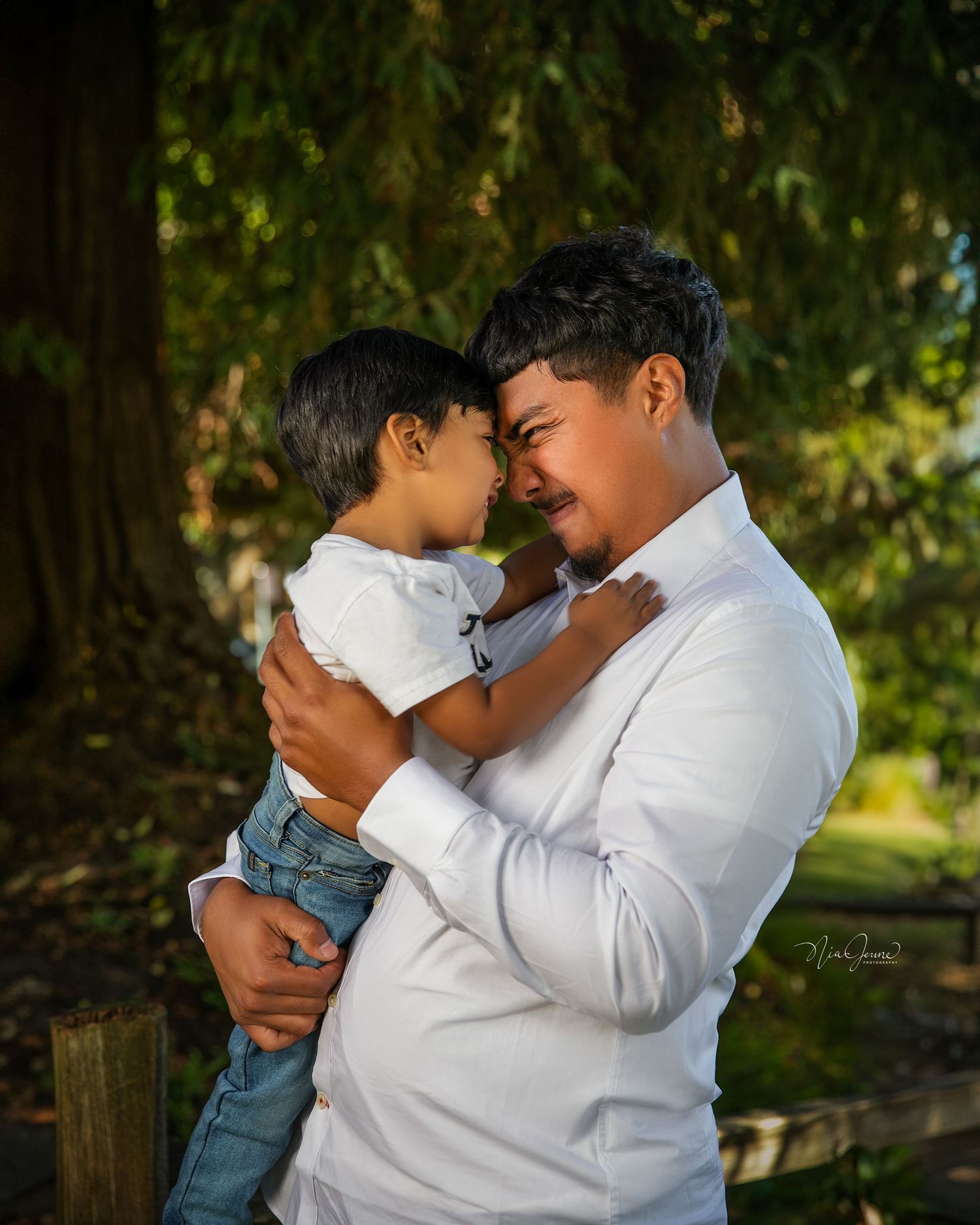 Tender moments captured between parent and child in white shirt against natural outdoor setting.