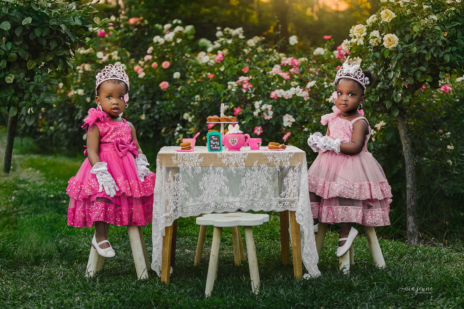 Little children enjoy a whimsical garden tea party with pink dresses and delicate decor on a summer afternoon.