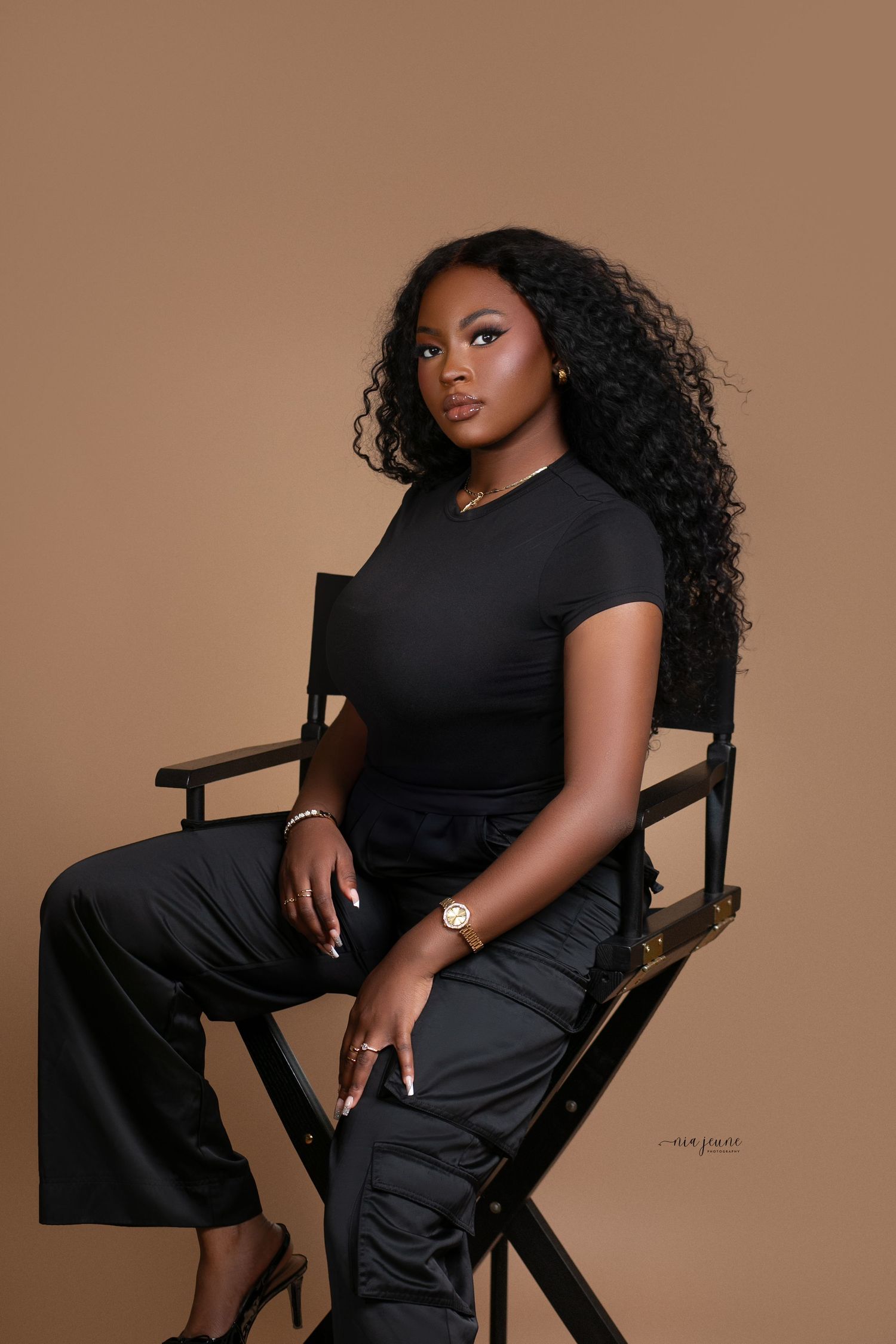 Studio portrait series of a model in black attire posed on a wooden chair against brown backdrop.