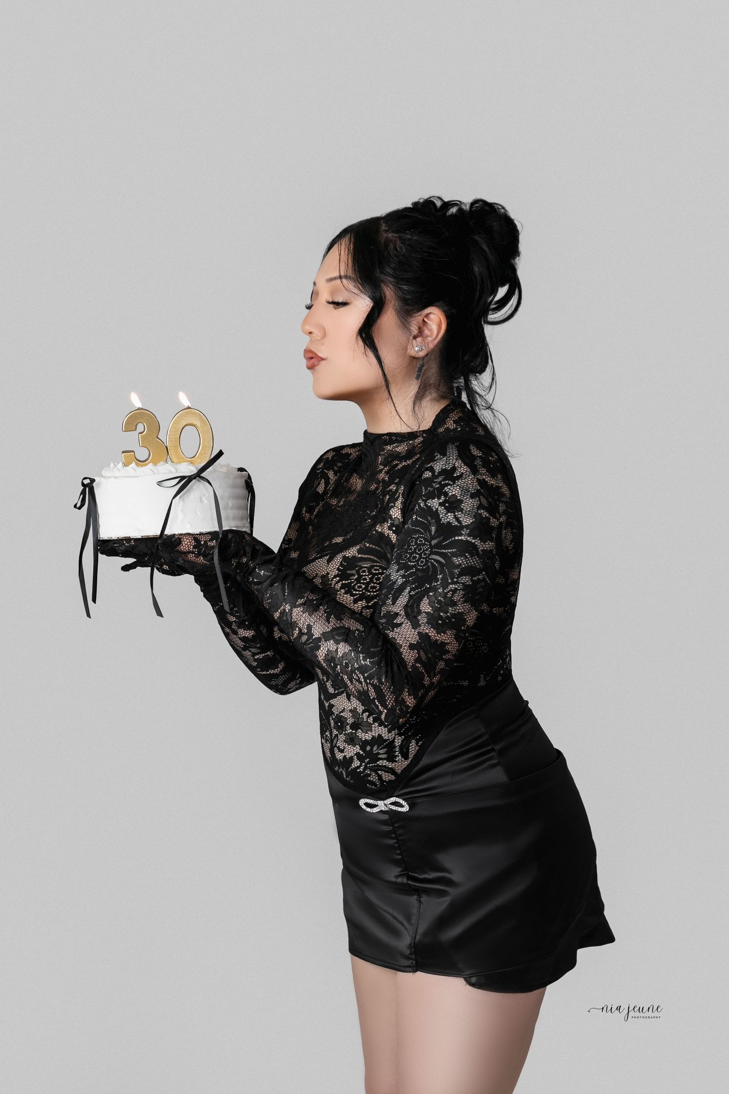 Birthday celebration photo with a black lace outfit and golden number 30 candle.