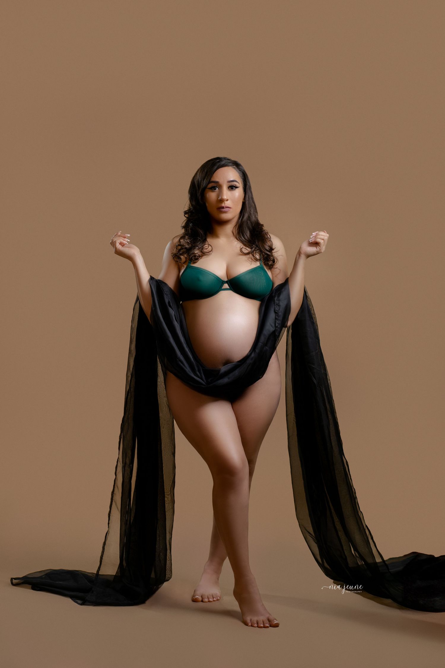 Artistic maternity portraits with flowing black fabric against neutral background.