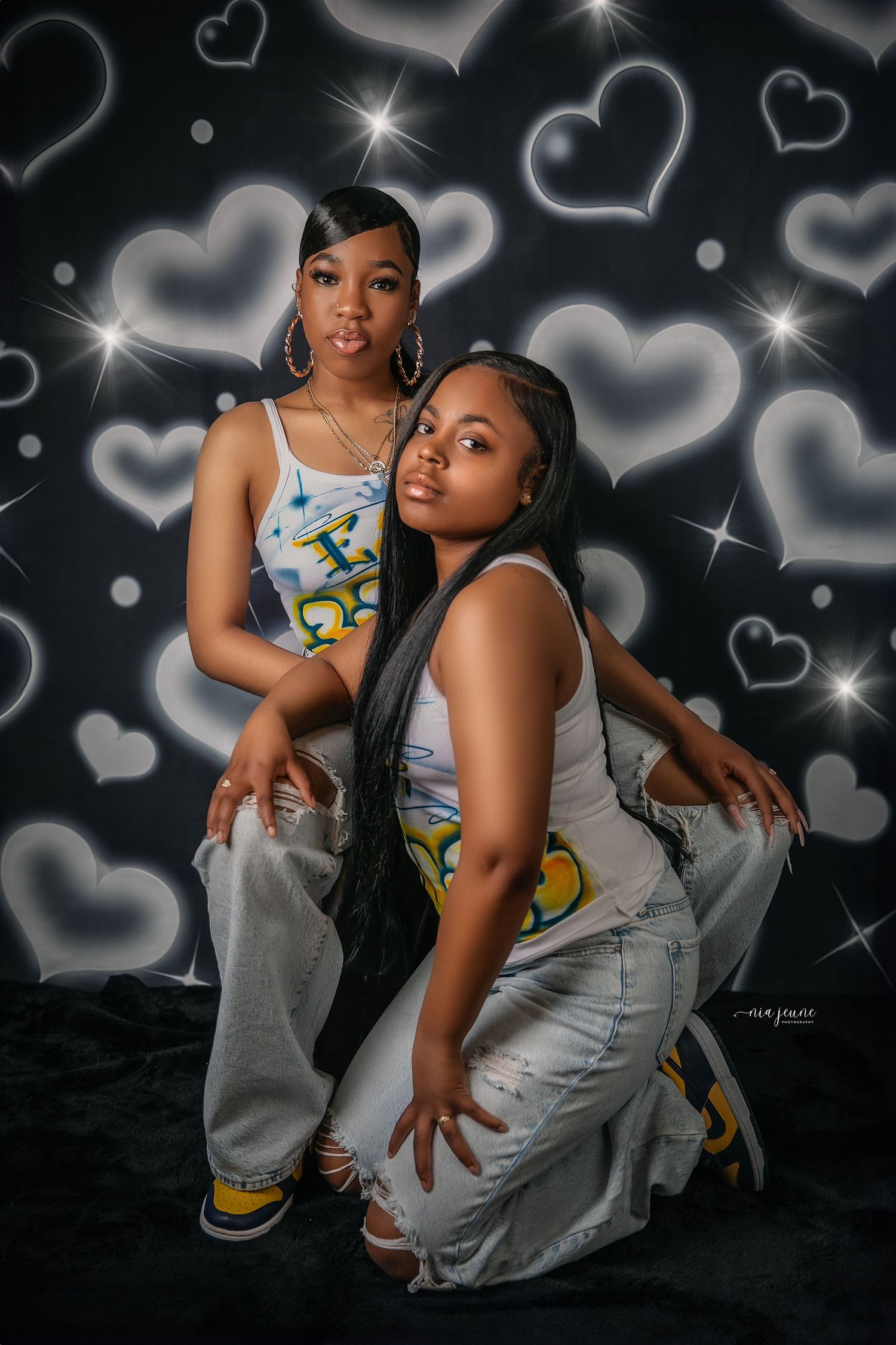 Mother and child photoshoot against black background with glowing heart designs.