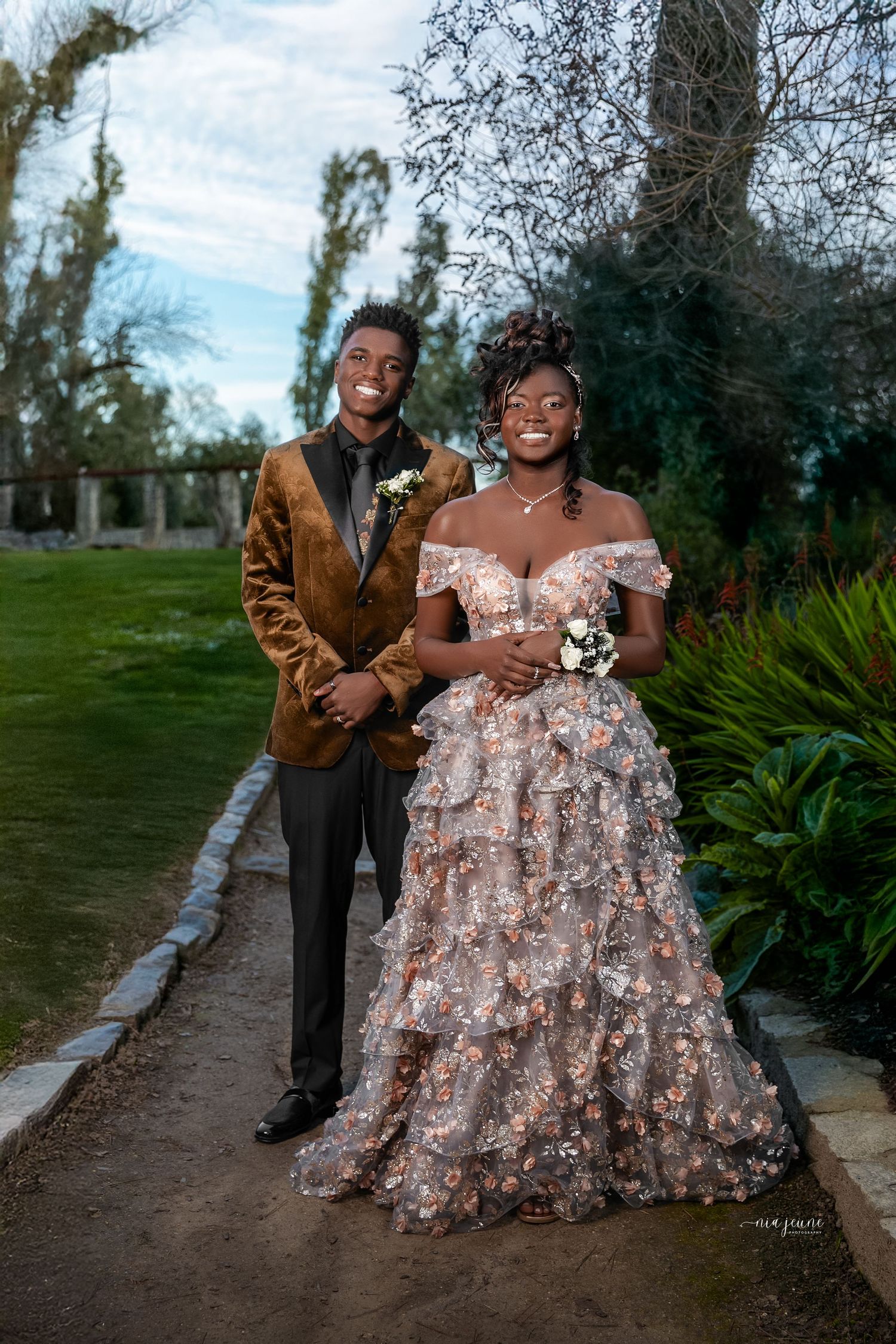 Outdoor engagement photos with floral dress and natural garden setting.