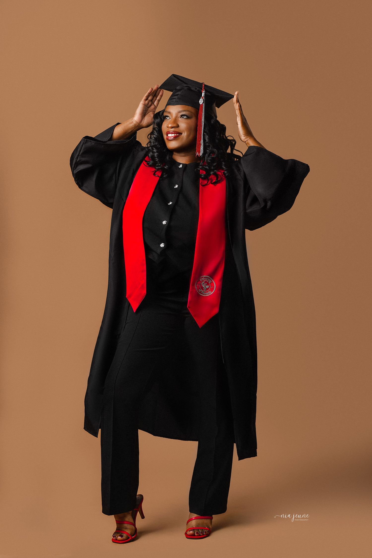 Graduate in black cap and gown with red stole poses in multiple artistic shots against brown backdrop.