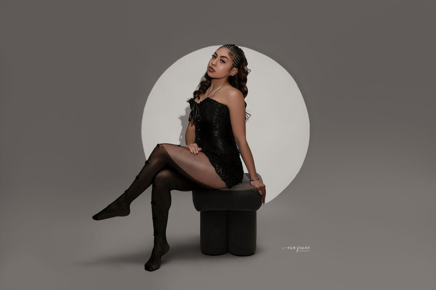 A dramatic black and white photo series shows a woman in dark clothing posing against a light backdrop.