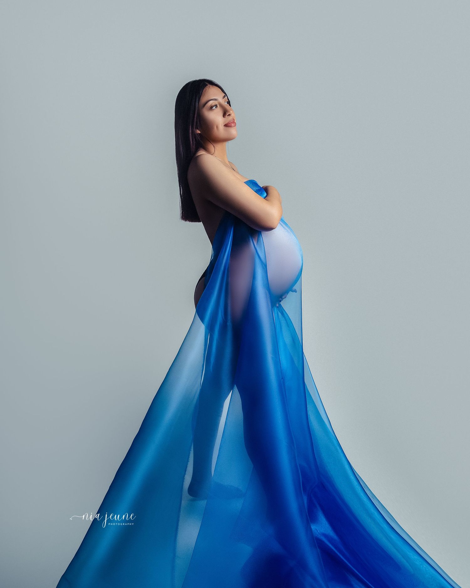 Fashion photo series showing flowing blue dress movement against light grey backdrop.
