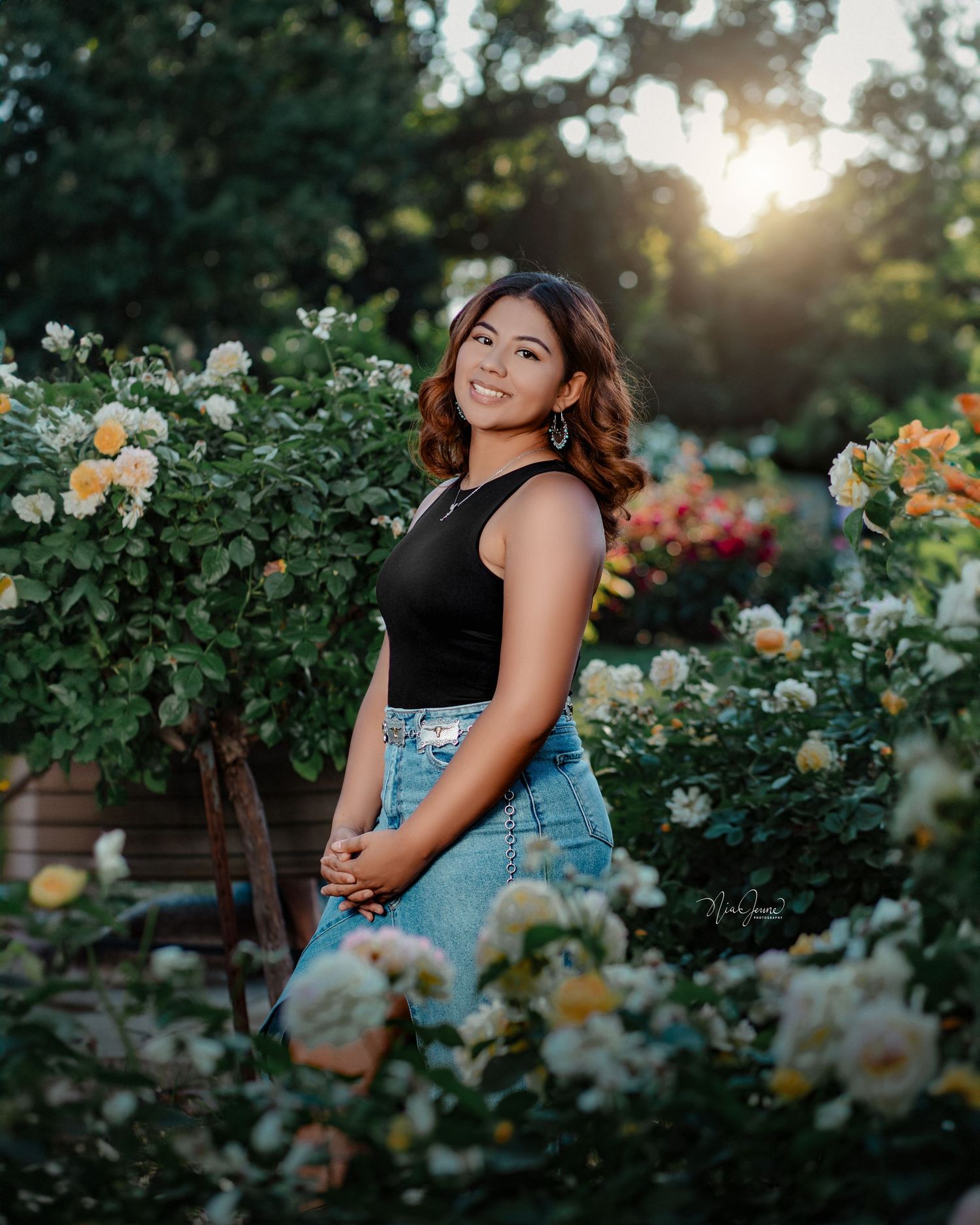 Portrait session in a blooming rose garden during golden hour sunset.