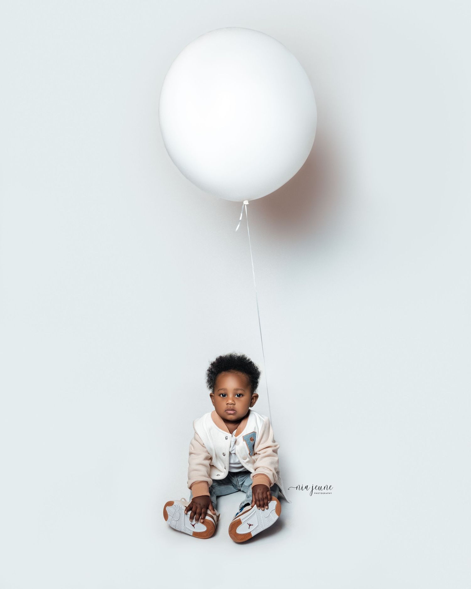 Artistic series showing a white balloon floating against minimalist white background.