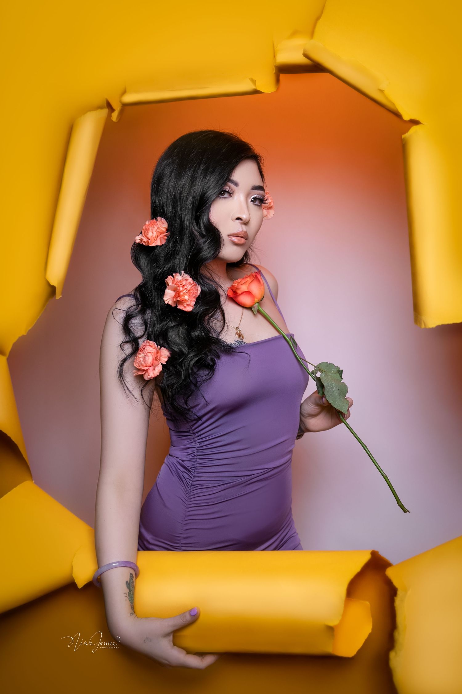 A series of artistic portraits against a vibrant yellow backdrop featuring purple clothing and pink flowers.