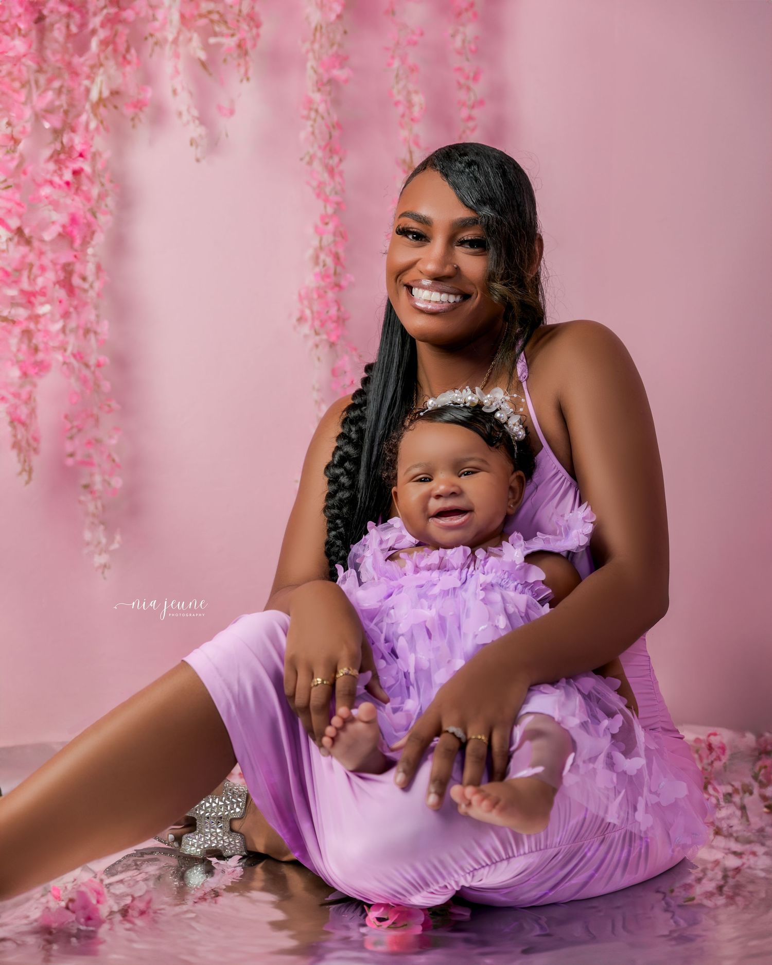 Mother and child portrait session with pink floral backdrop and lavender tulle outfits.
