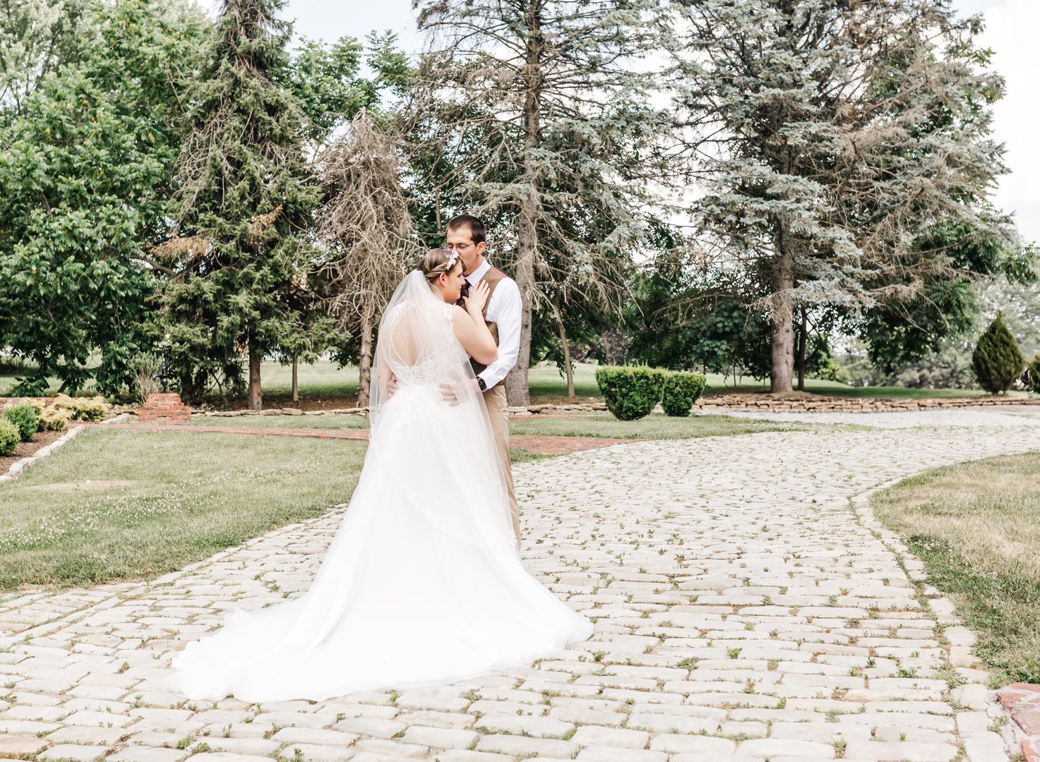 Wedding couple posing on a stone pathway surrounded by evergreen trees. Pittsburgh wedding Photographer
