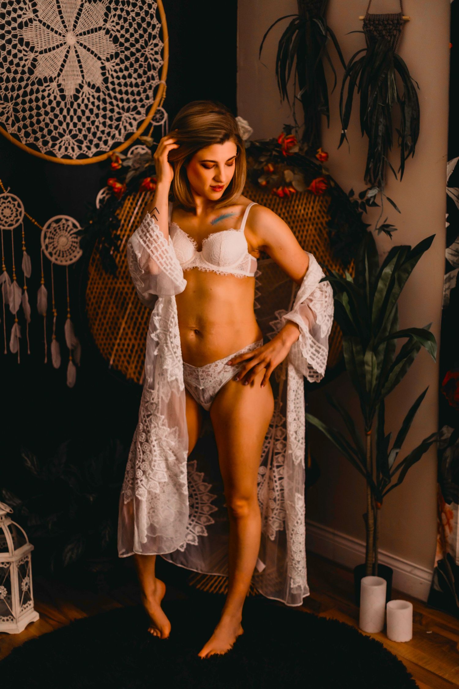 Bohemian styled boudoir photo with lace robe and dreamcatcher wall decor.