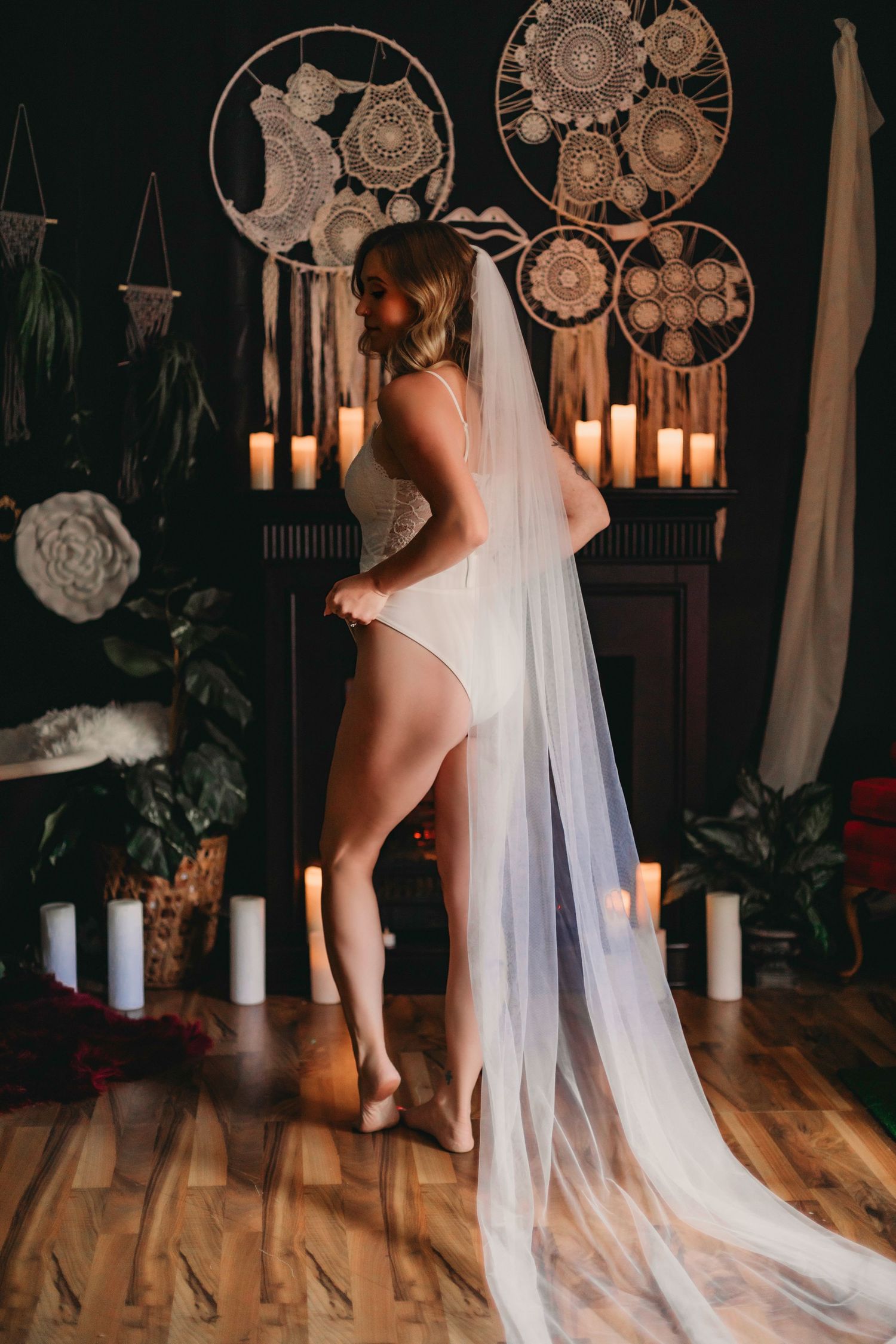 Ethereal bridal boudoir photo with candlelight and circular dreamcatchers.