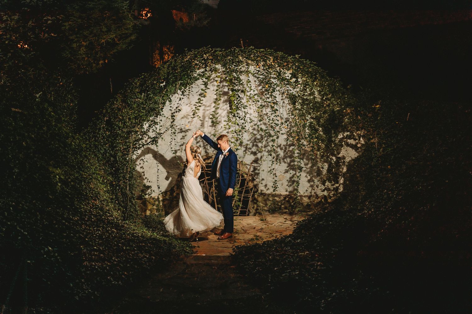 A wedding couple stands in a magical tunnel-like archway covered in vines. Pittsburgh wedding Photographer