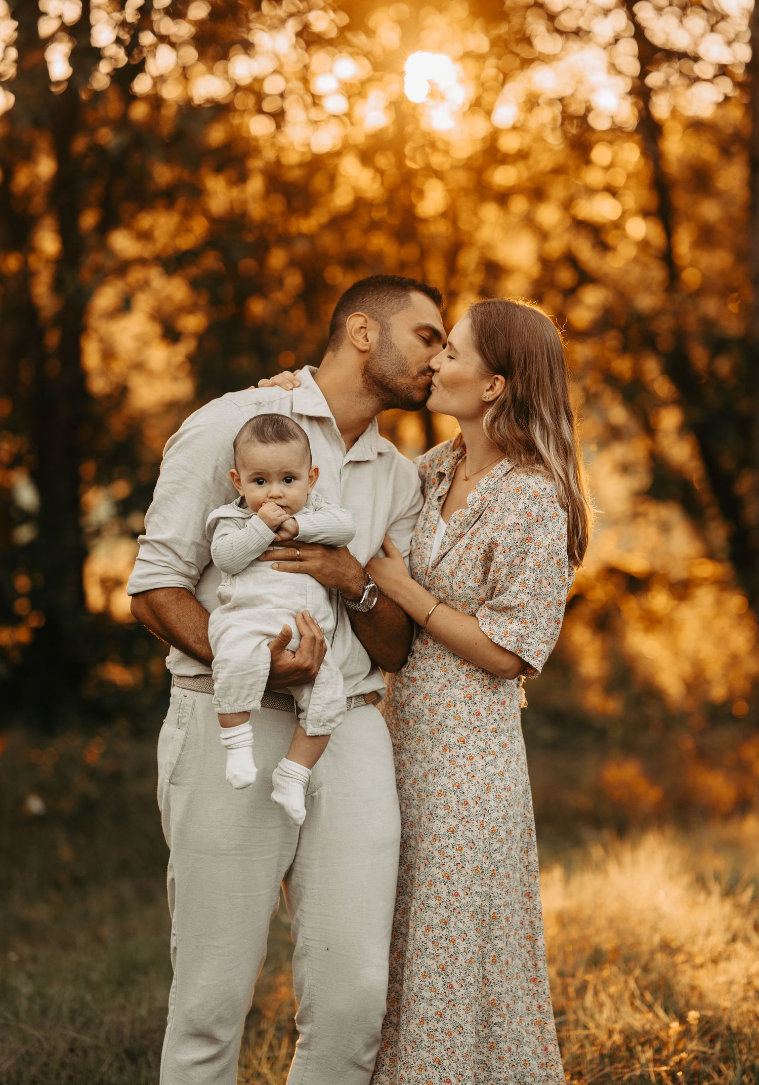 Golden sunset family portrait in autumn forest setting.