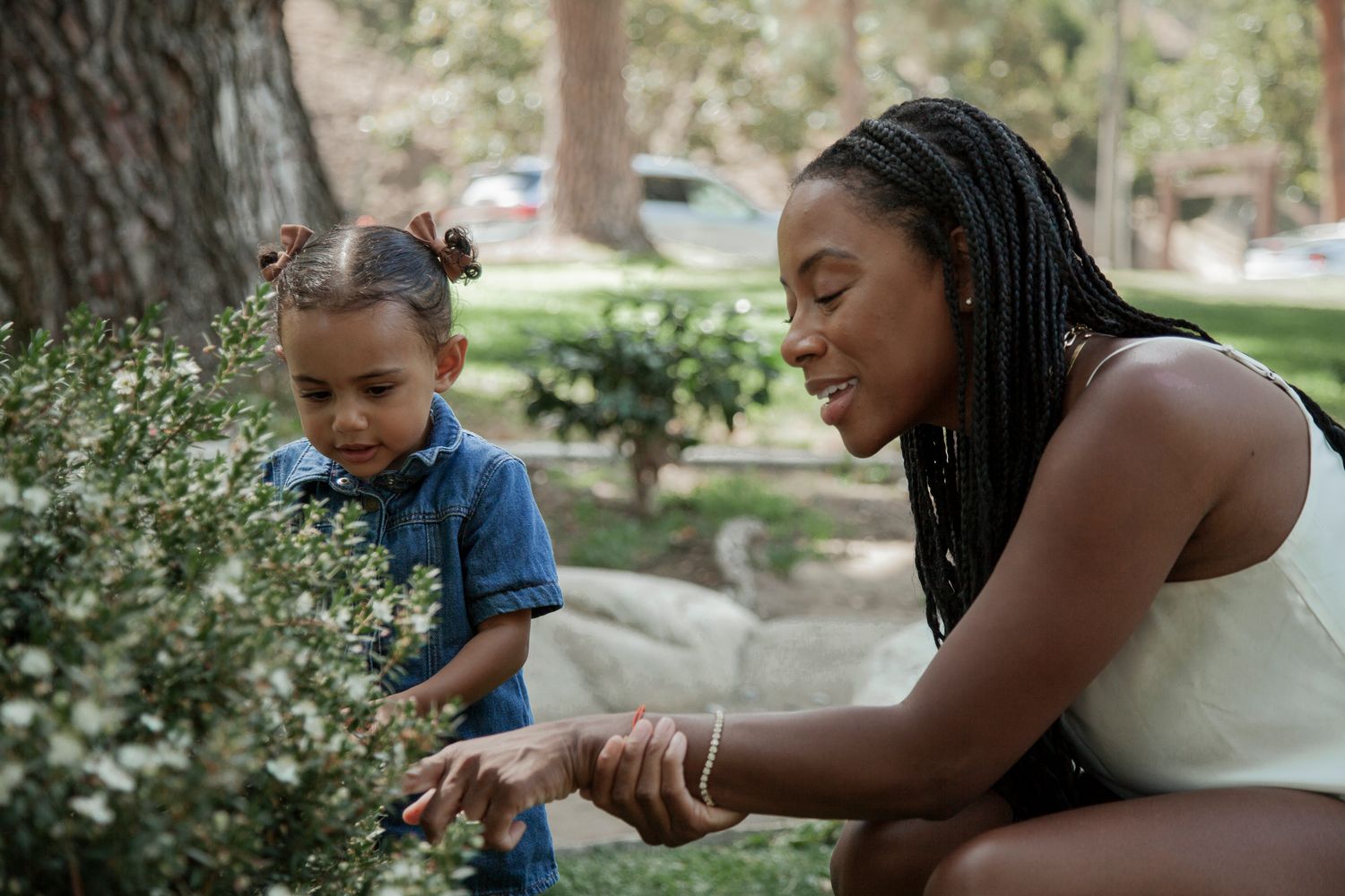 A series of photos showing a parent and child playing together outdoors in a garden setting.