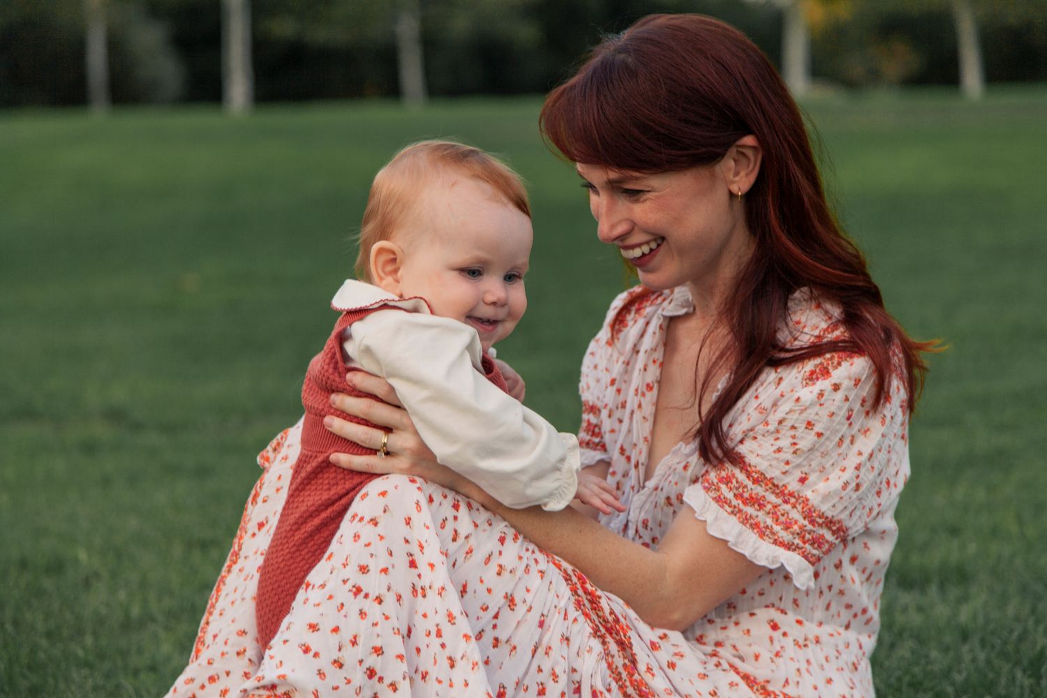 Baby and parent sharing sweet moments together on green grass.