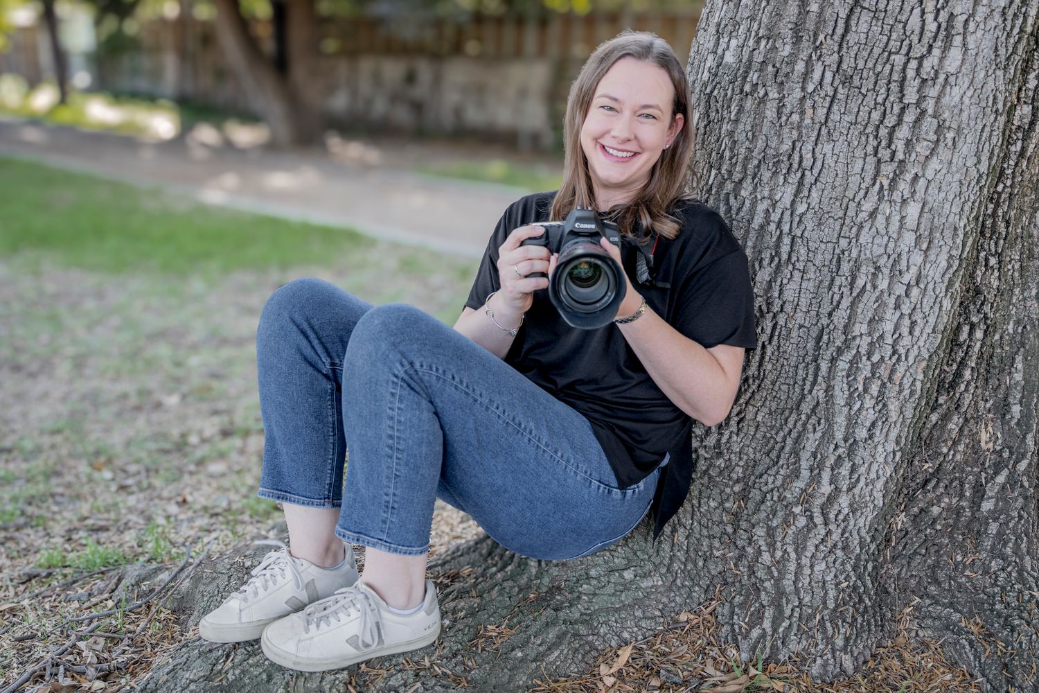 Casual portrait session featuring relaxed poses against a tree trunk.