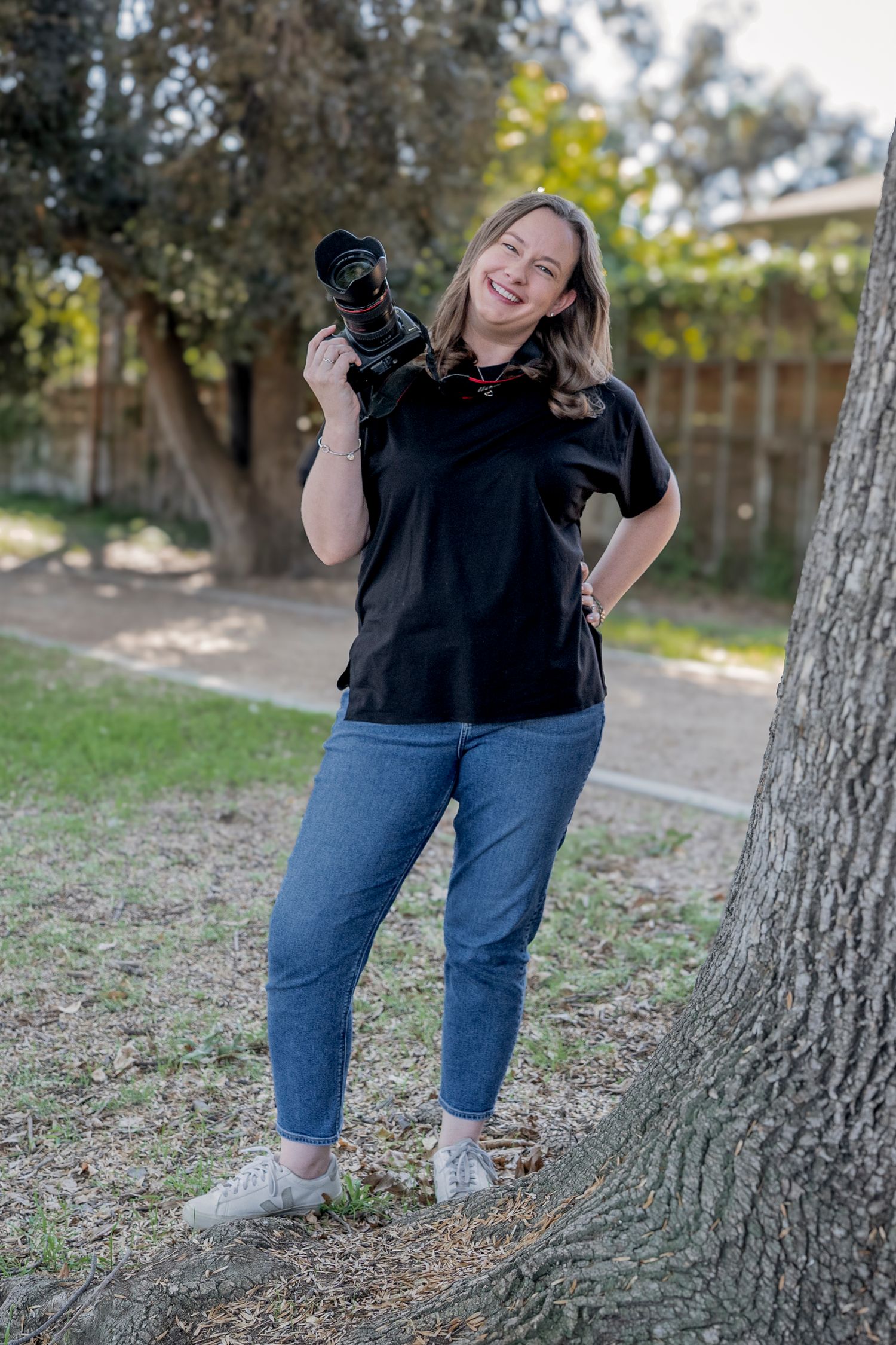 Candid photography session showing joyful moments around a tree.
