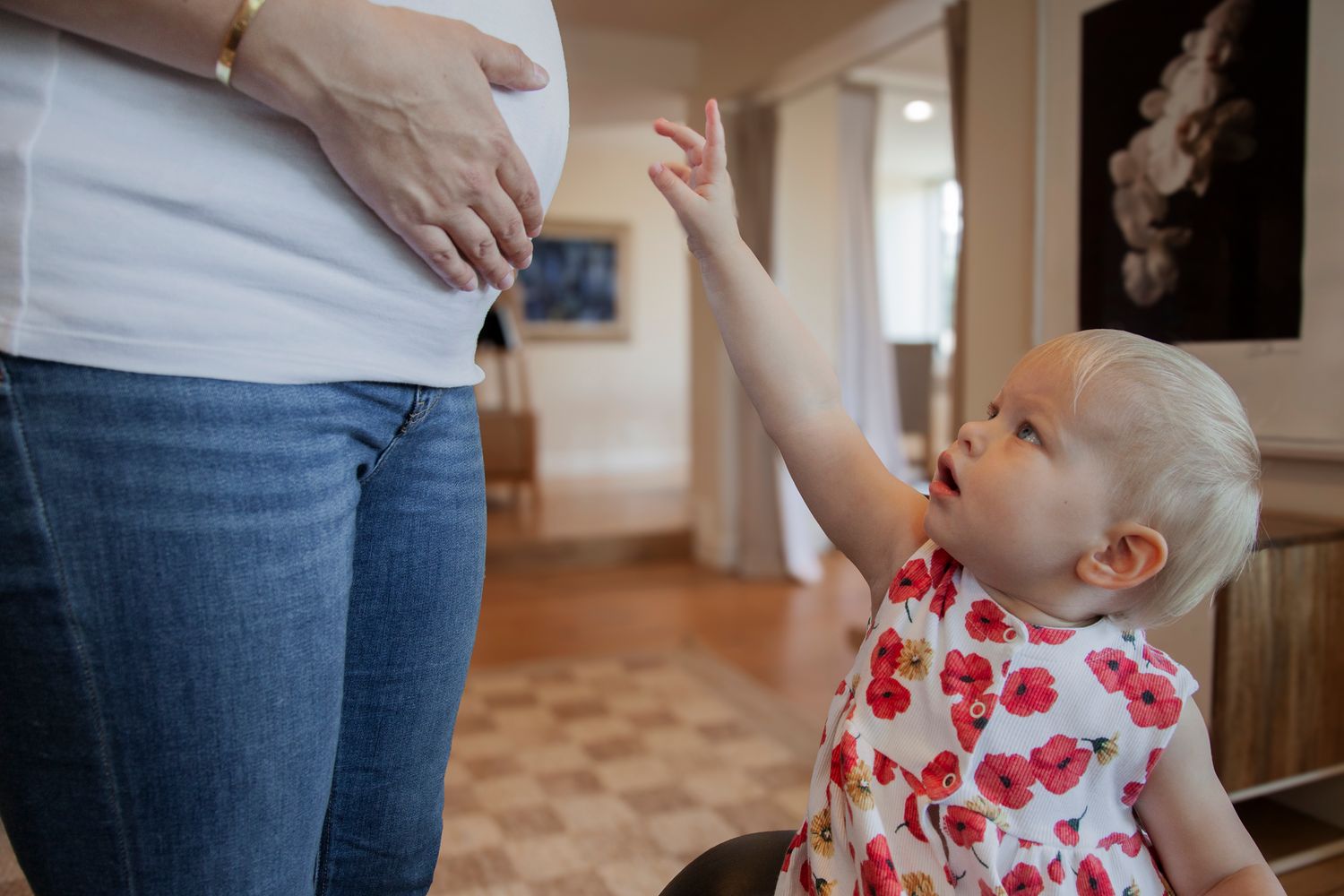 Close-up shots of hands interacting with a small child wearing a floral dress.