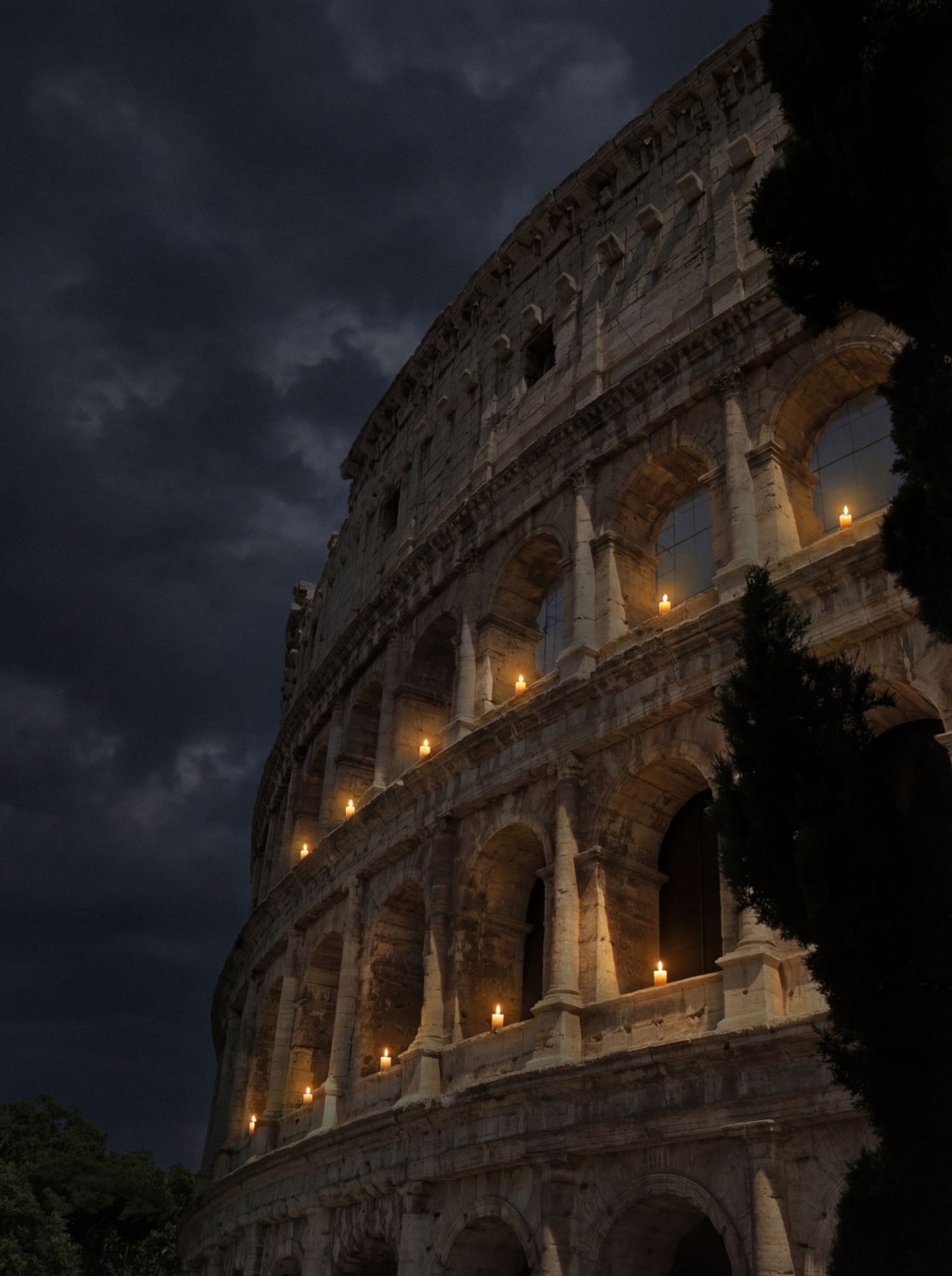 The Colosseum in Rome illuminated at night with dramatic storm clouds looming overhead.