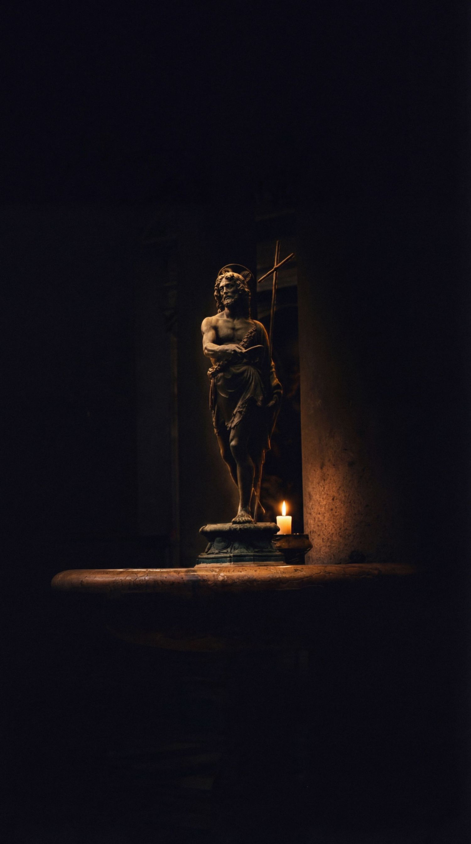 A dark and moody series of photographs showing a bronze statue illuminated by dramatic spotlighting against a black background.