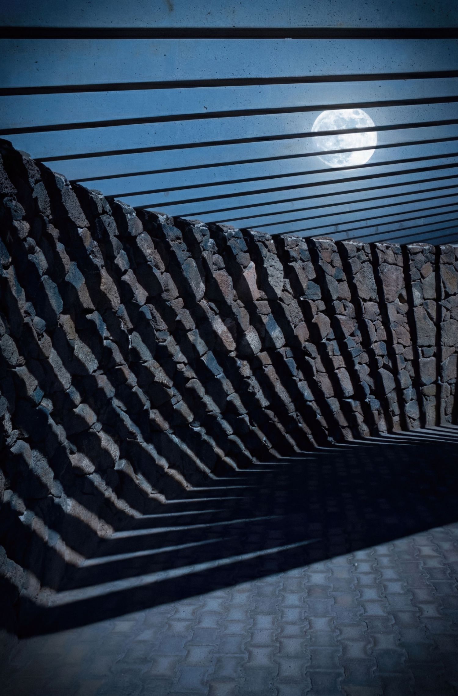 Abstract architectural detail of dark geometric steps creating dramatic shadows and patterns in a modern structure.