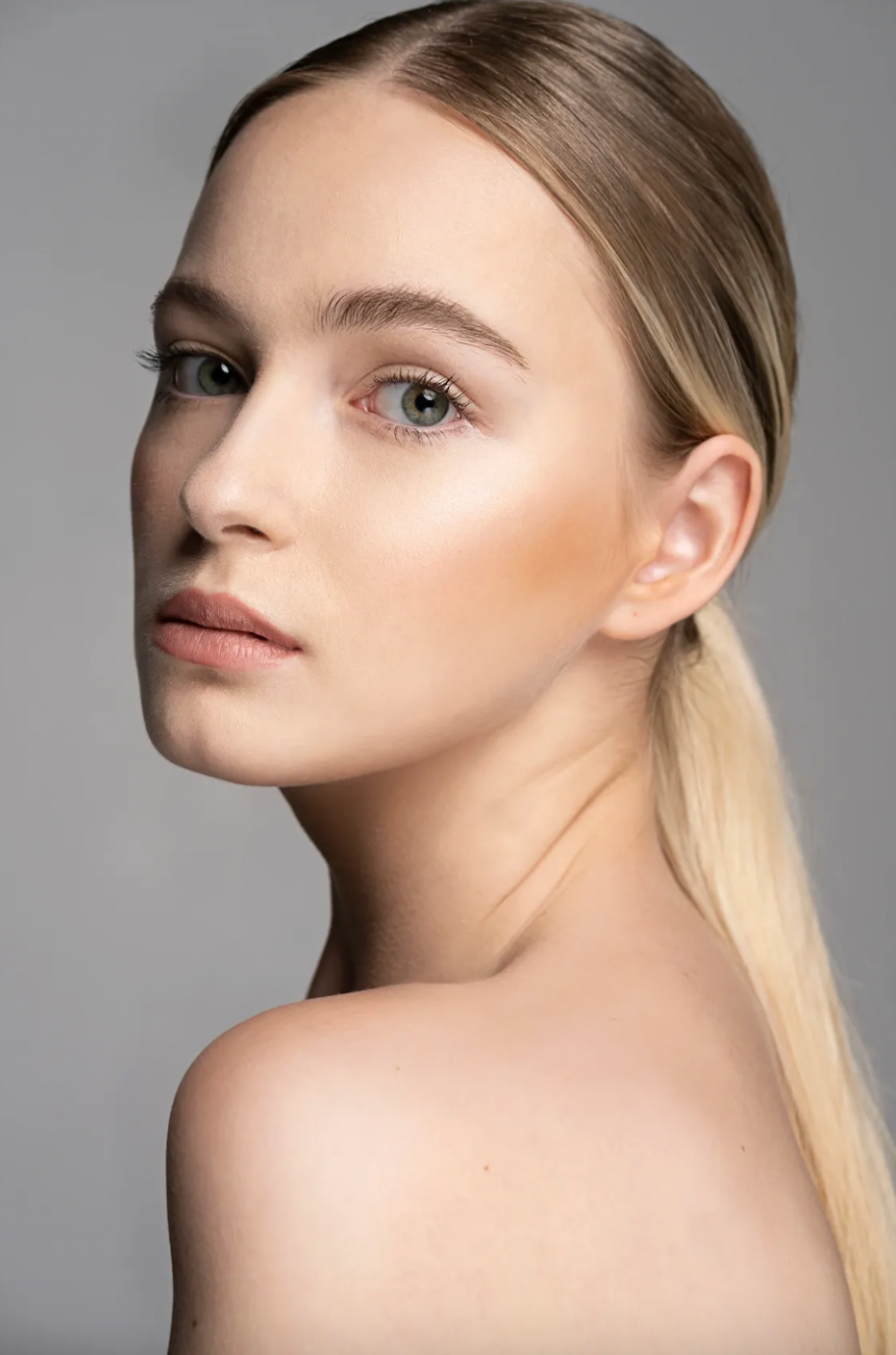 Beauty portrait series showing soft makeup and blonde hair against gray background.