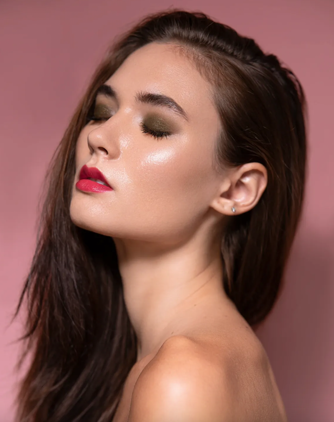 Glamour beauty series with dramatic makeup and dark hair against pink background.