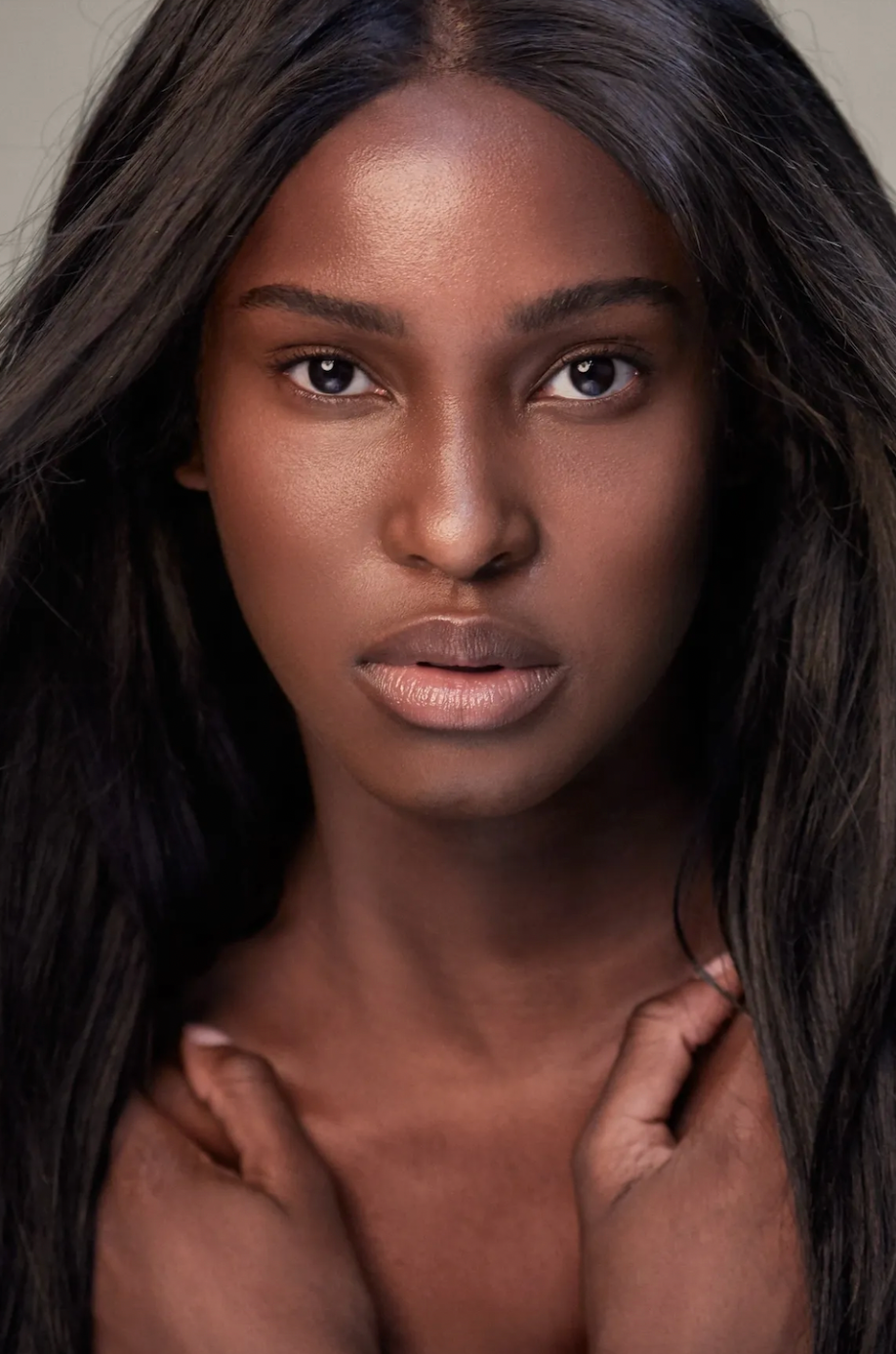 A series of close-up beauty portraits showing dark skin and natural black hair against a neutral background.