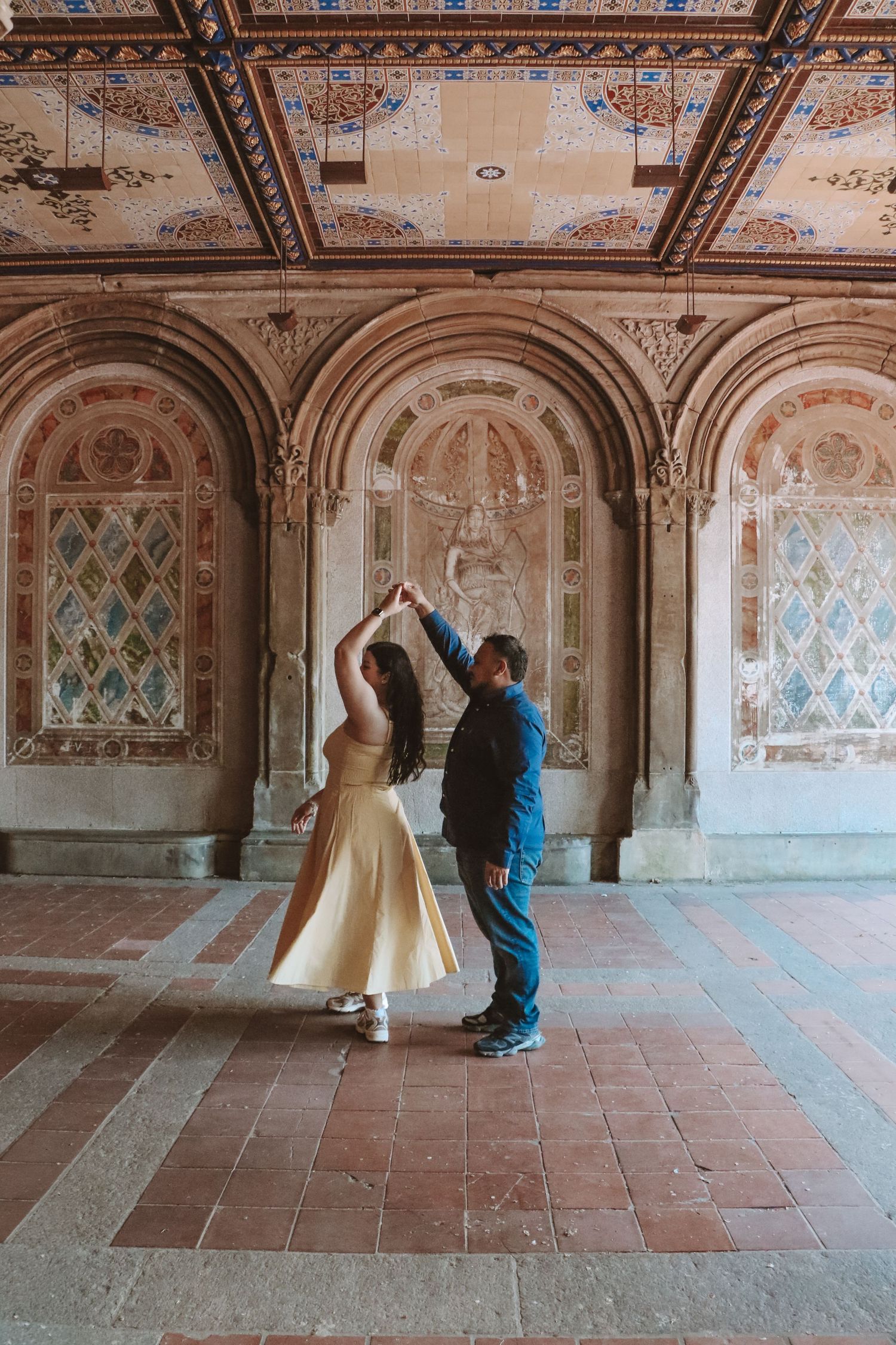 Couple dancing gracefully under ornate arched ceilings at Bethesda Terrace in Central Park, New York City.