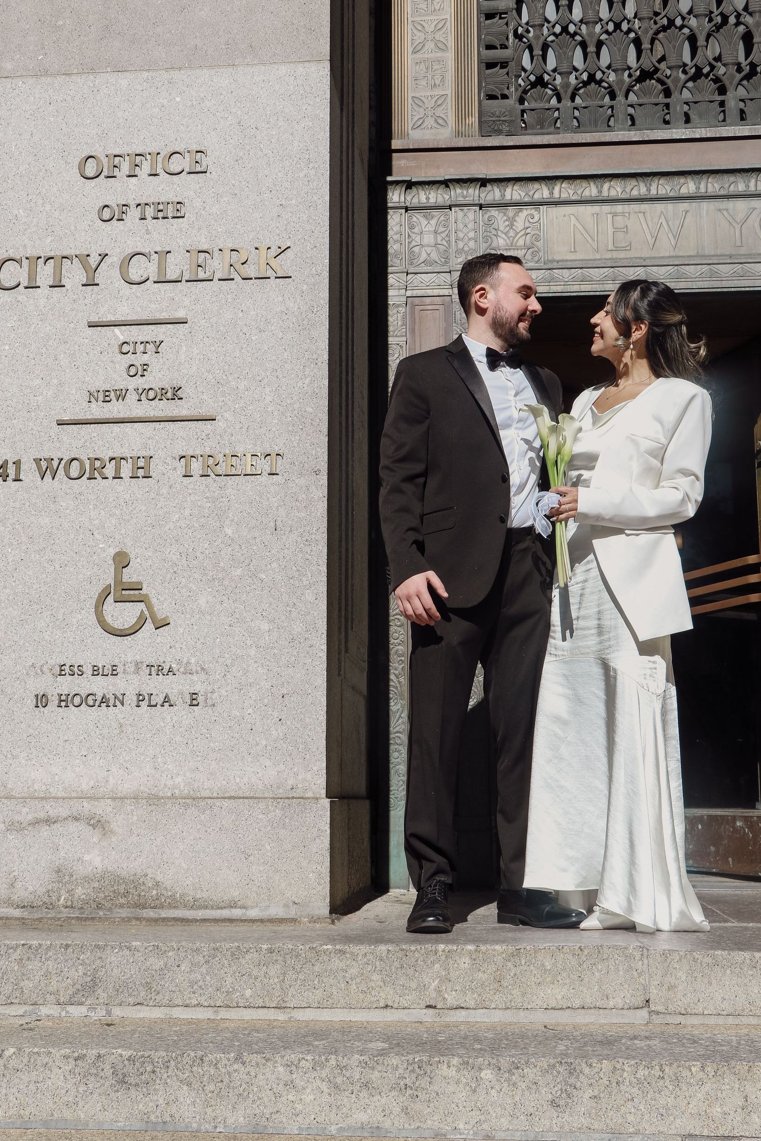 Couple poses at NYC Office of the City Clerk on Worth Street after their civil wedding ceremony.
