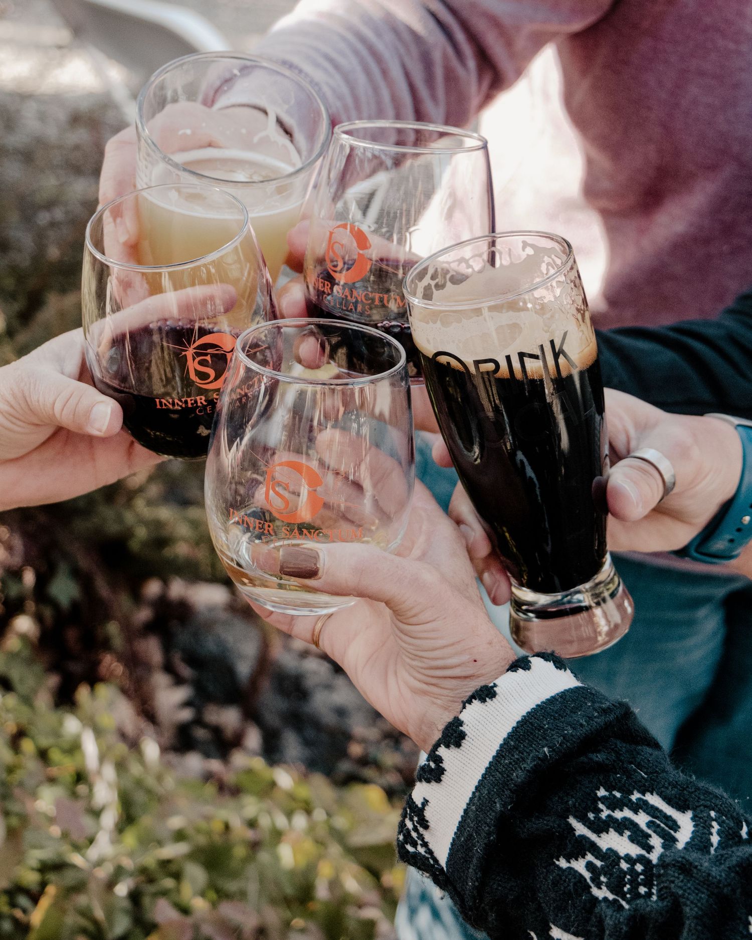 people cheers their  glasses together in a circle