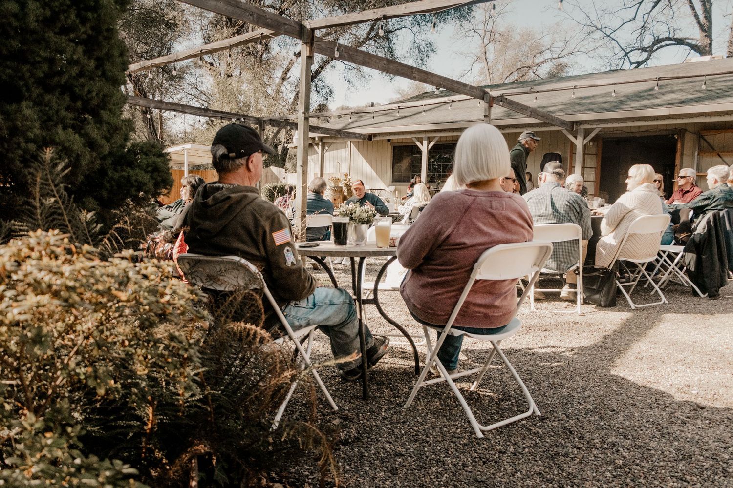 couple sits at table while drinking wine and listening to live music
