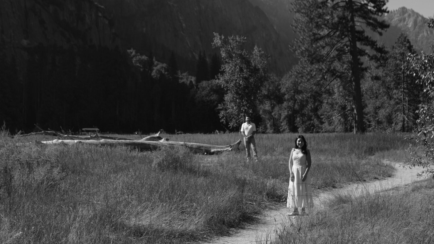 black and whitte photo of couple standing off set along a path in yosemite