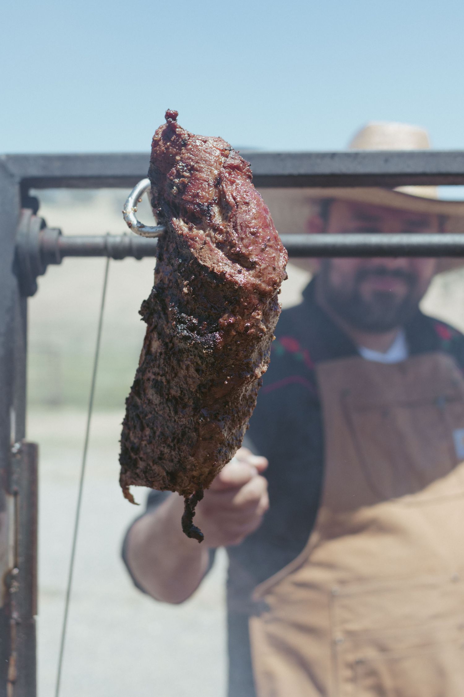 chef holds up smoked tri-tip before him