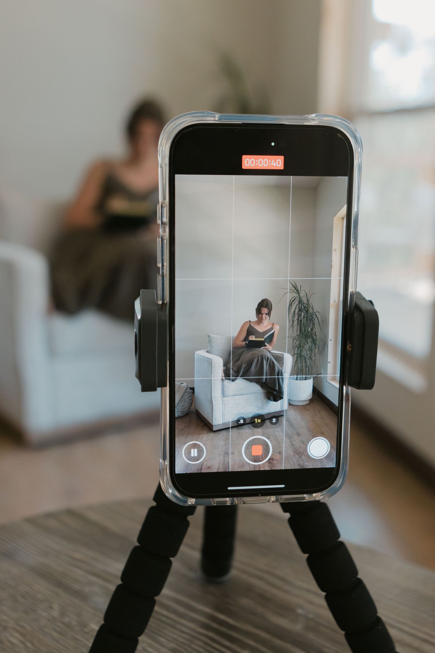 photo of a person taking a video of themselves sitting in a chair