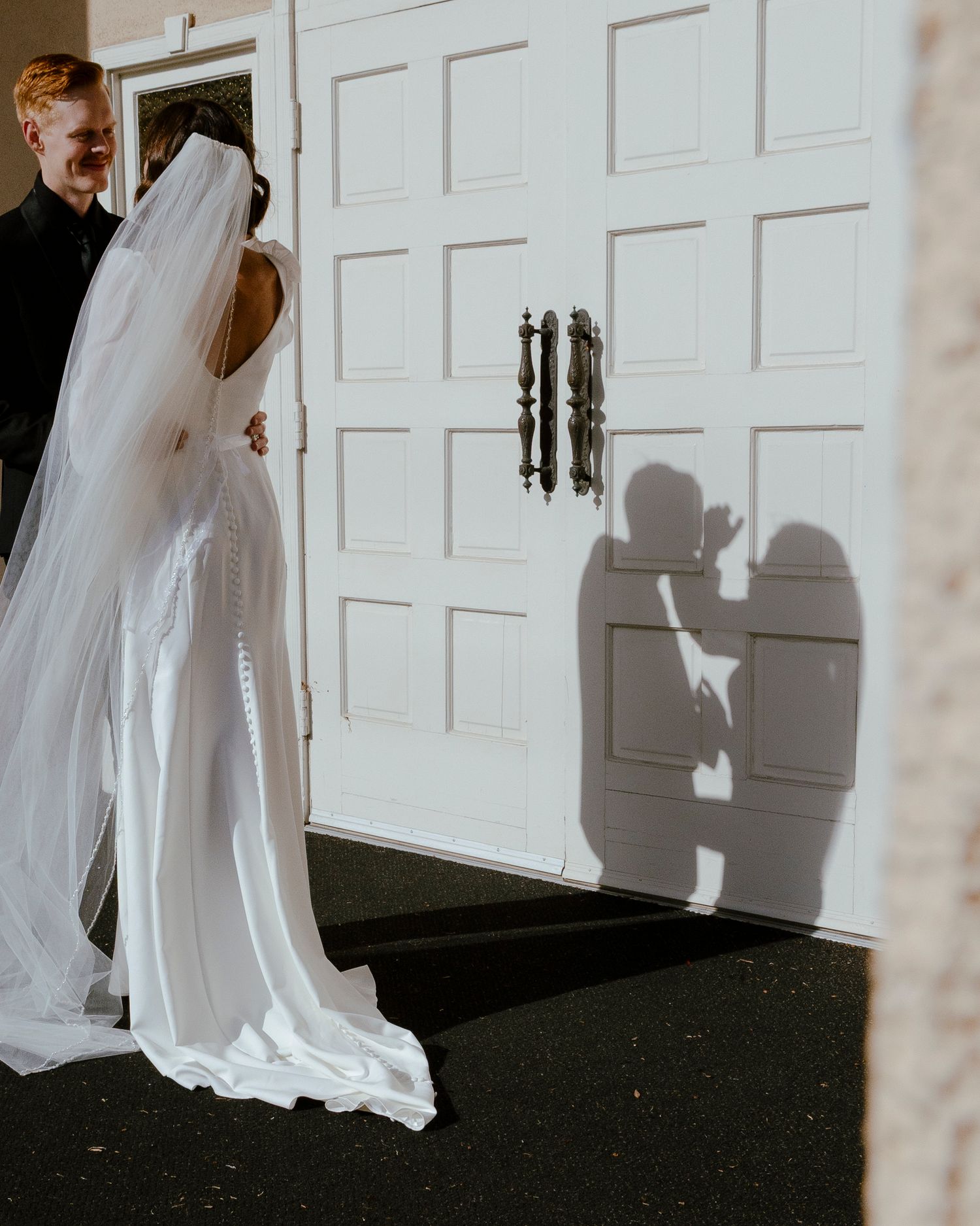 bride and grooms shadows on front door of church