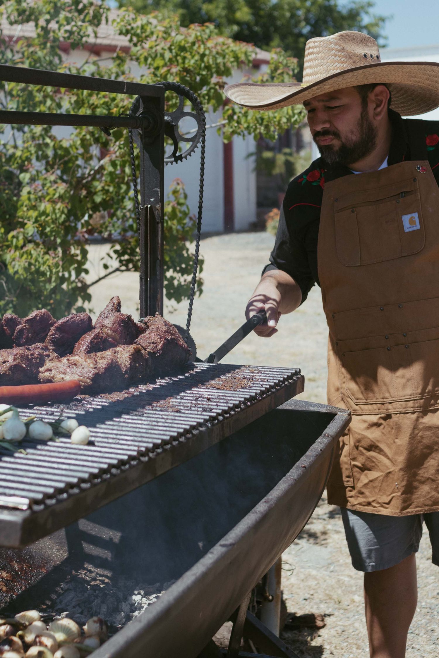 Chef lowers rack of smoker to cook tri-tips