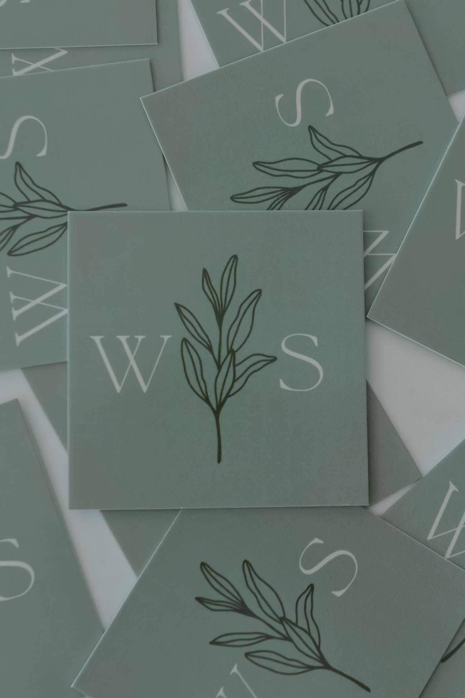 scattered pile of sage green business cards