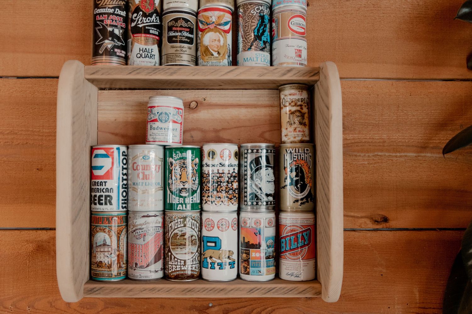 shelf lined with vintage beer cans