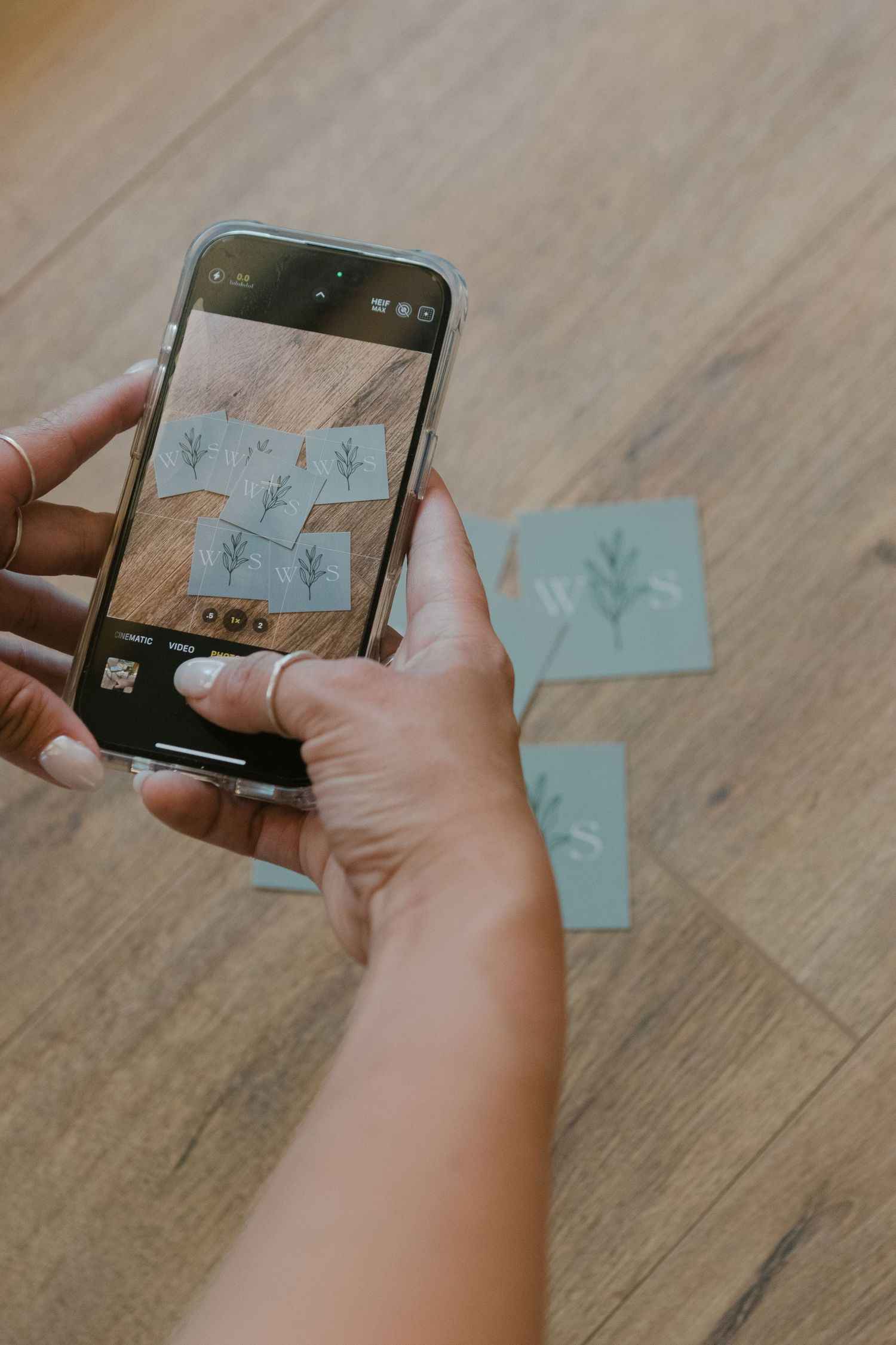 person takes photo of business cards with phone