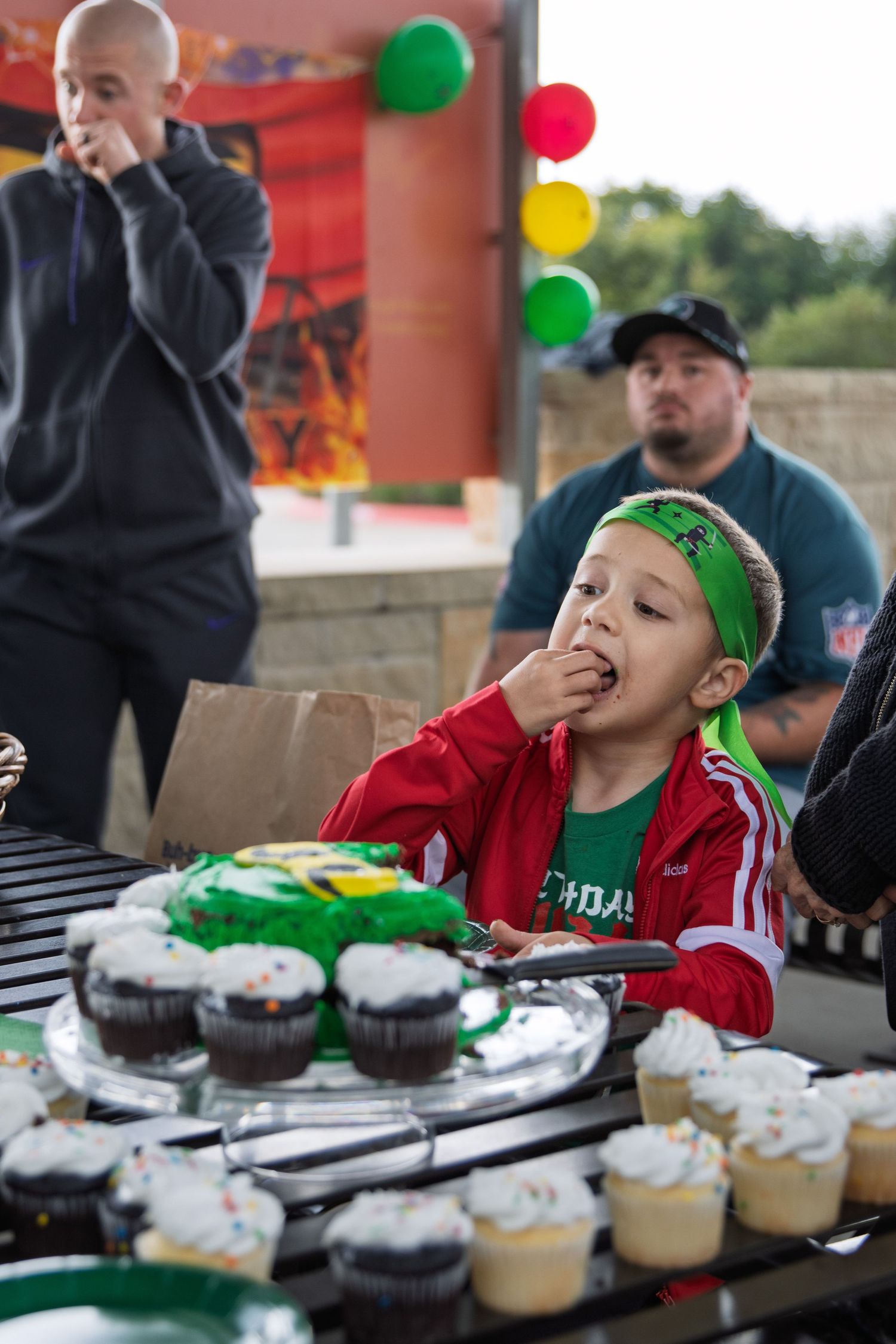 happy candid kids and adults celebrating birthday outdoors with cake and playful moments natural light family portrait photography session
