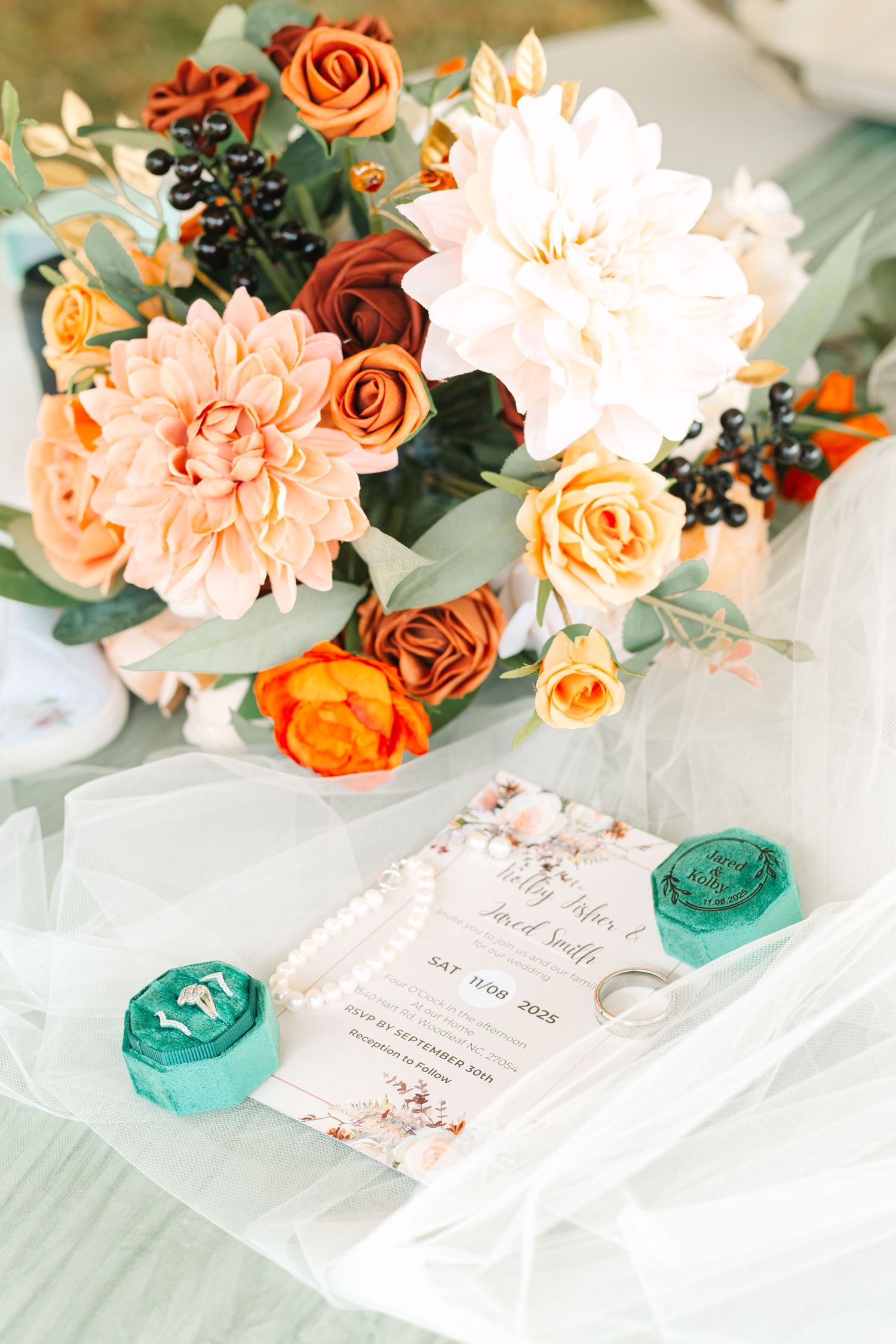 Elegant floral arrangements with peach and orange roses alongside turquoise decor on white tablecloths.