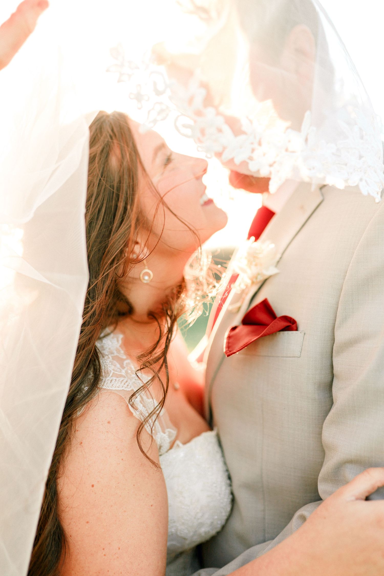 Romantic wedding couple sharing an intimate moment in a light-filled setting.