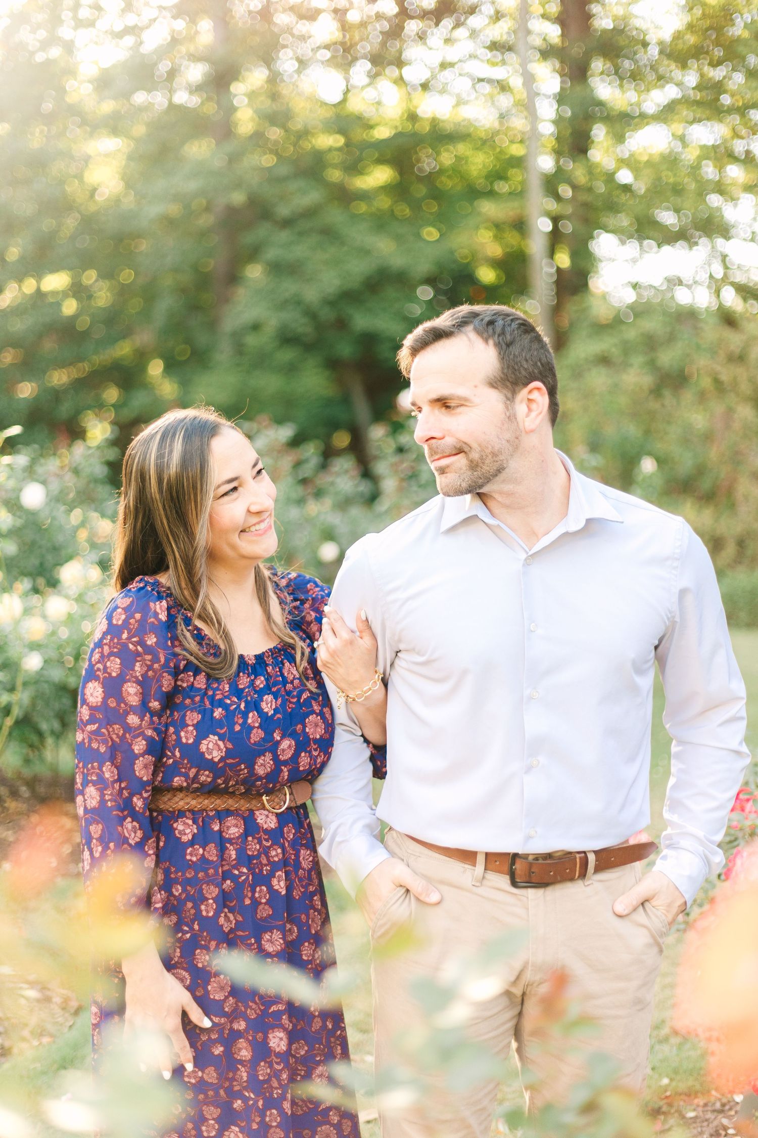Couple laughing together during outdoor photo session in golden sunlight.