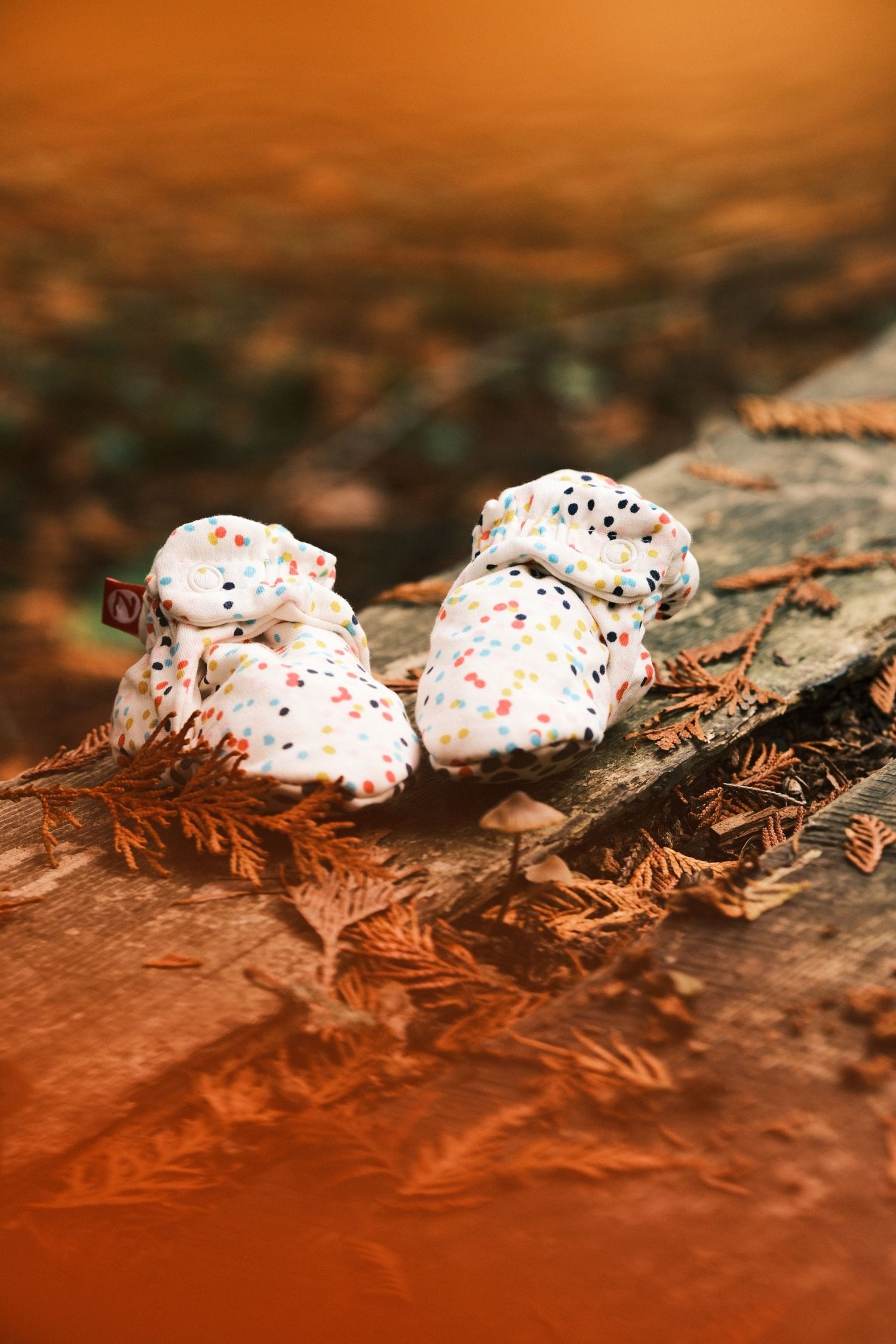 Row of white frosted meringues with colorful sprinkles on a rustic surface.