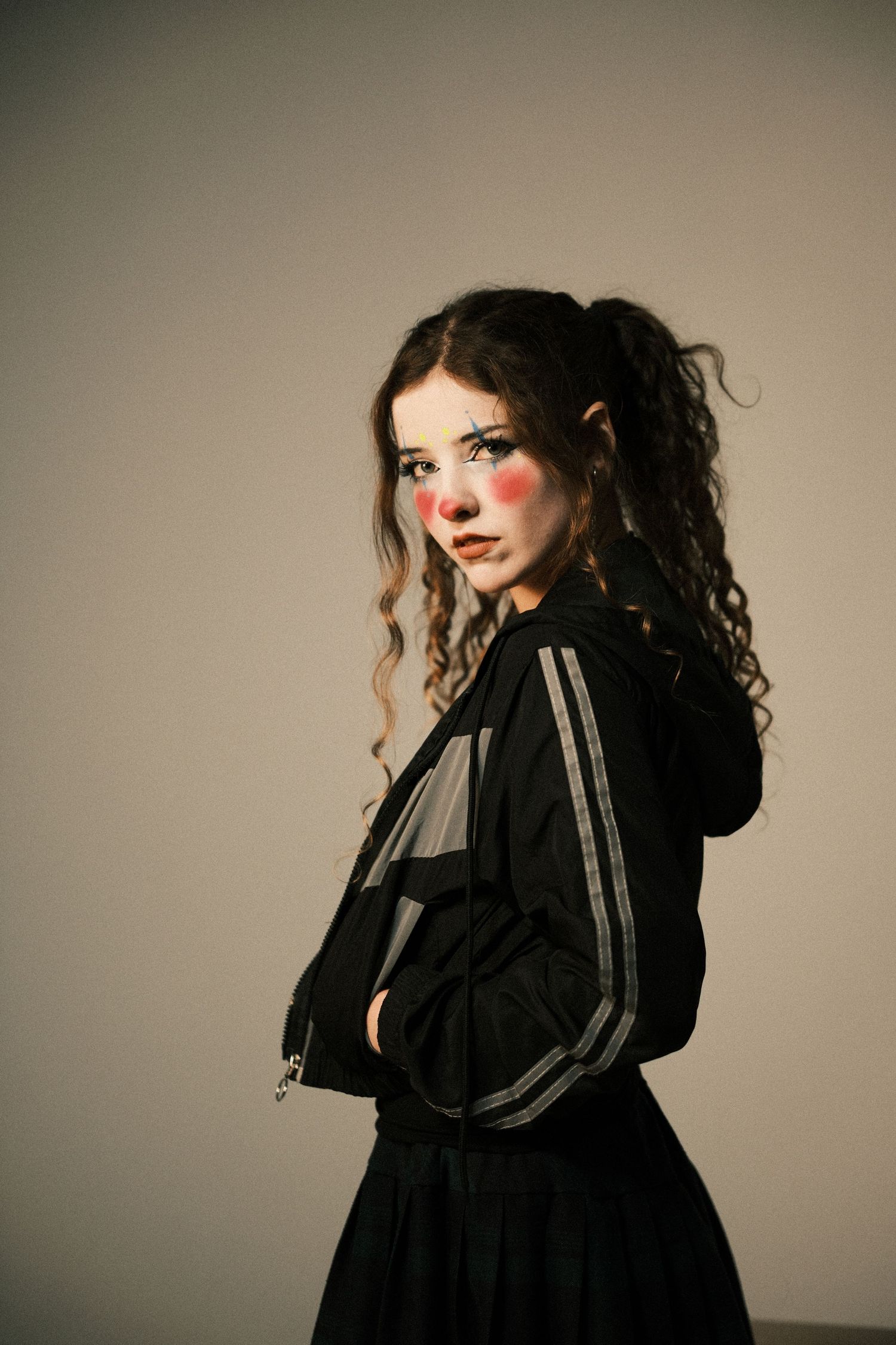 Fashion portrait series of person in black jacket against neutral background.