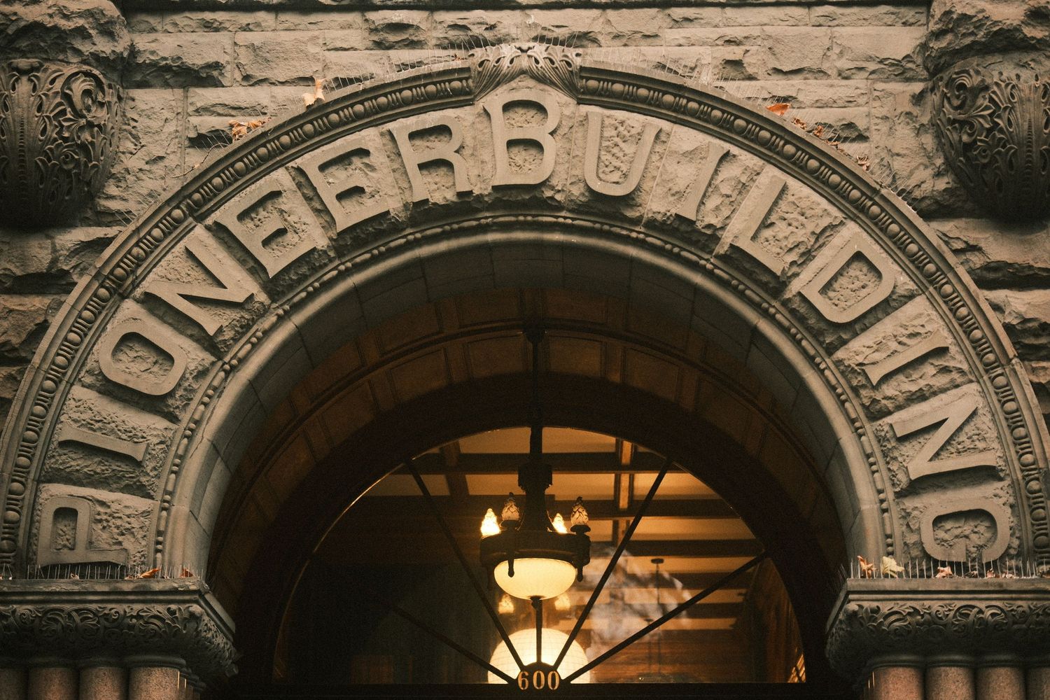 Historic stone archway with ornate architectural details and illuminated entrance.