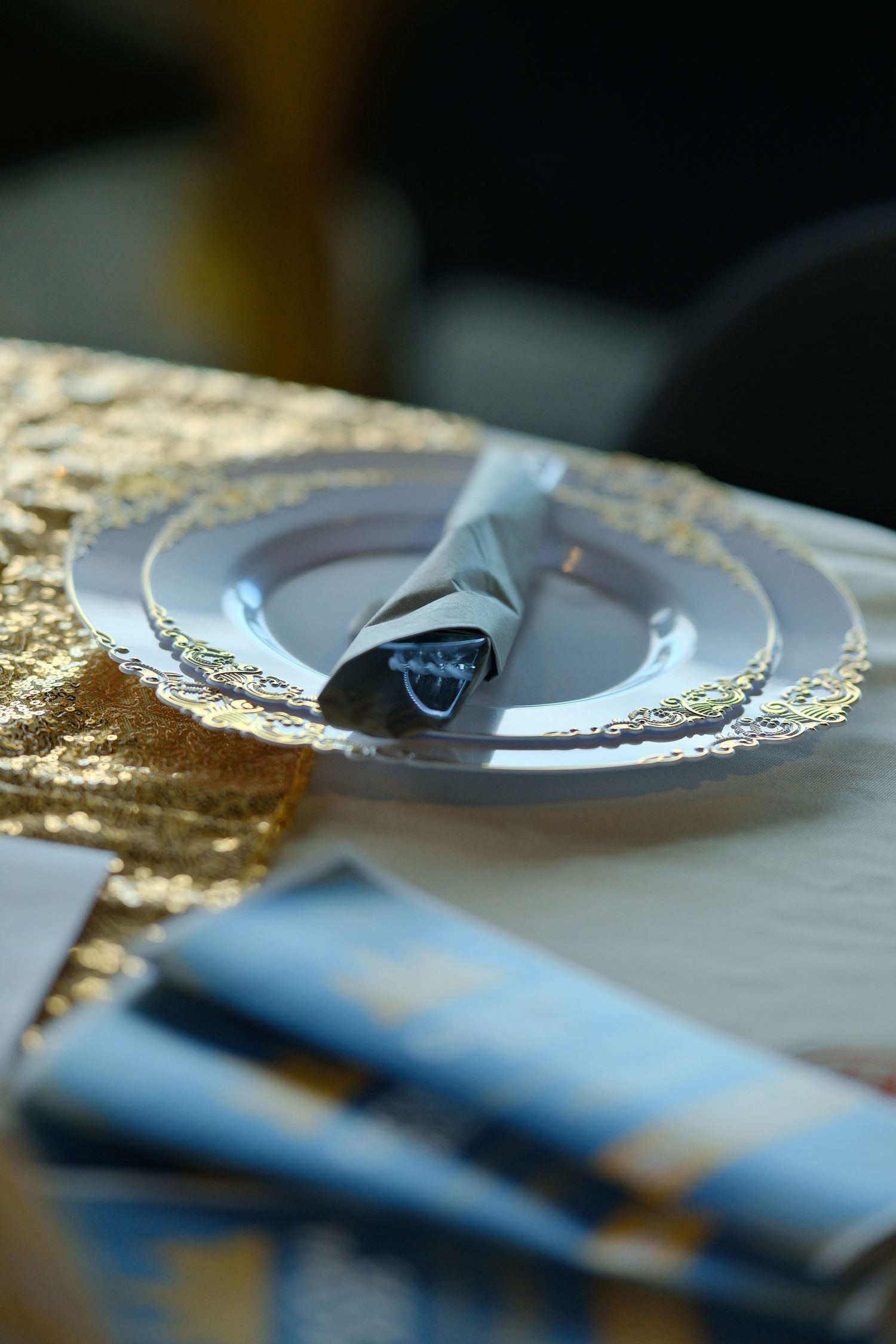 Elegant place setting with decorative gold-rimmed plate and folded napkin.